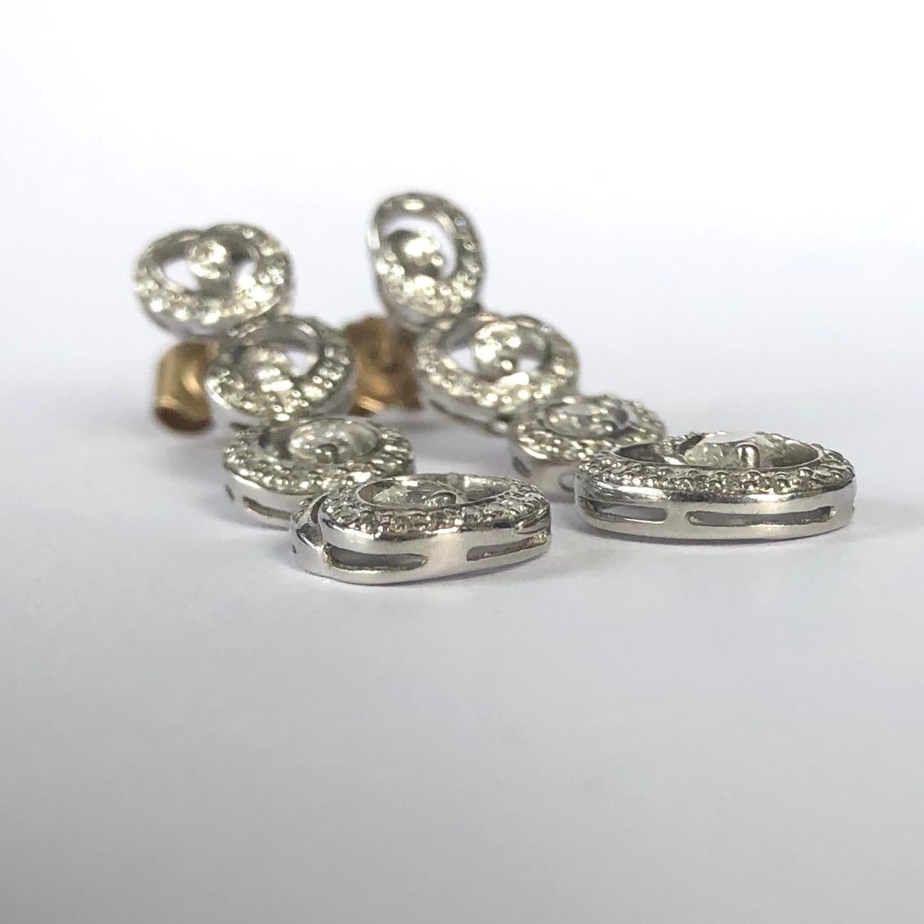 Both these stunning drop earrings boast a total of 60pts worth of diamonds. The largest diamond sits at the centre of a swirl shaped halo of diamonds at the bottom of the drop earrings and the smallest are in the stud. The style of these earrings