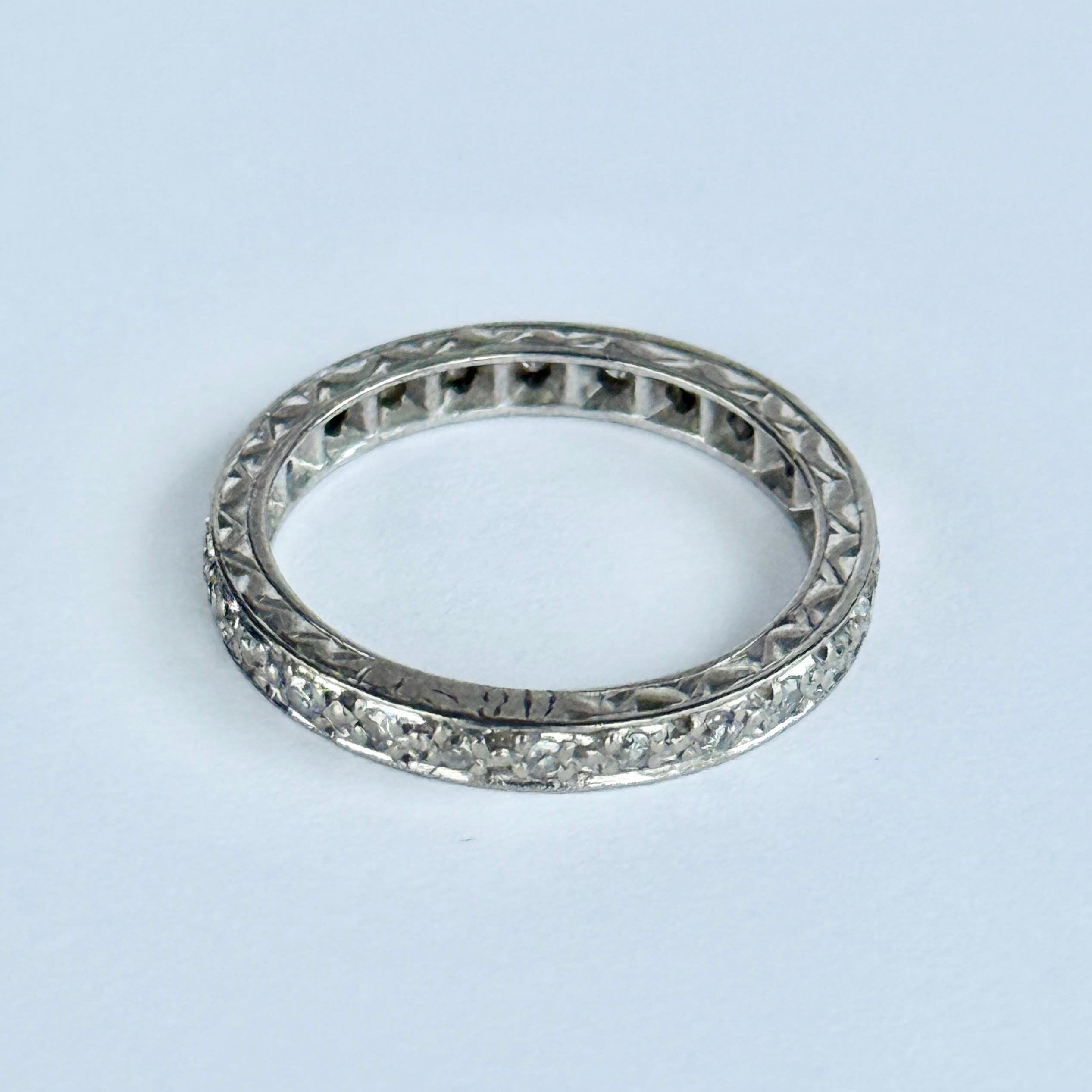 Les délicats diamants ronds qui sont enchâssés dans cette bague mesurent environ 1 pt chacun et la bande est modelée en or blanc 18 carats. Le bracelet lui-même est magnifiquement gravé sur tout son pourtour. 

Taille de la bague : K ou 5