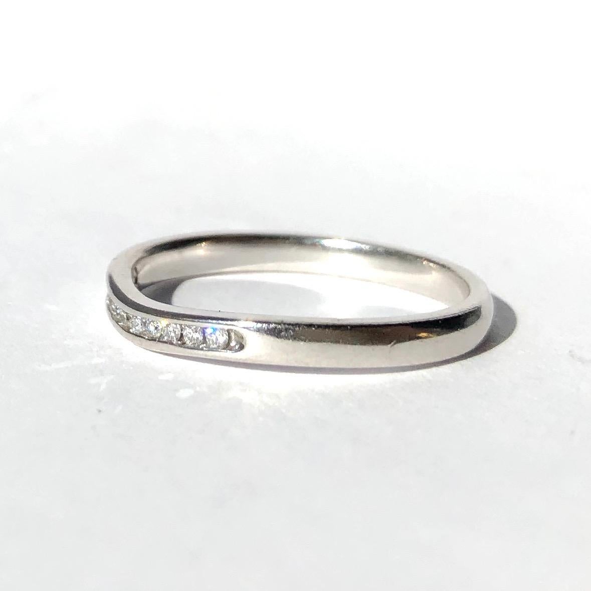 Eleven small yet glistening diamonds sit within this 18ct white gold band. The stones each measure 1pt and the band has a very subtle 'V' shape to it where the diamonds are set. 

Ring Size: N 1/2 or 7
Band Width: 2mm 

Weight: 2.6g 