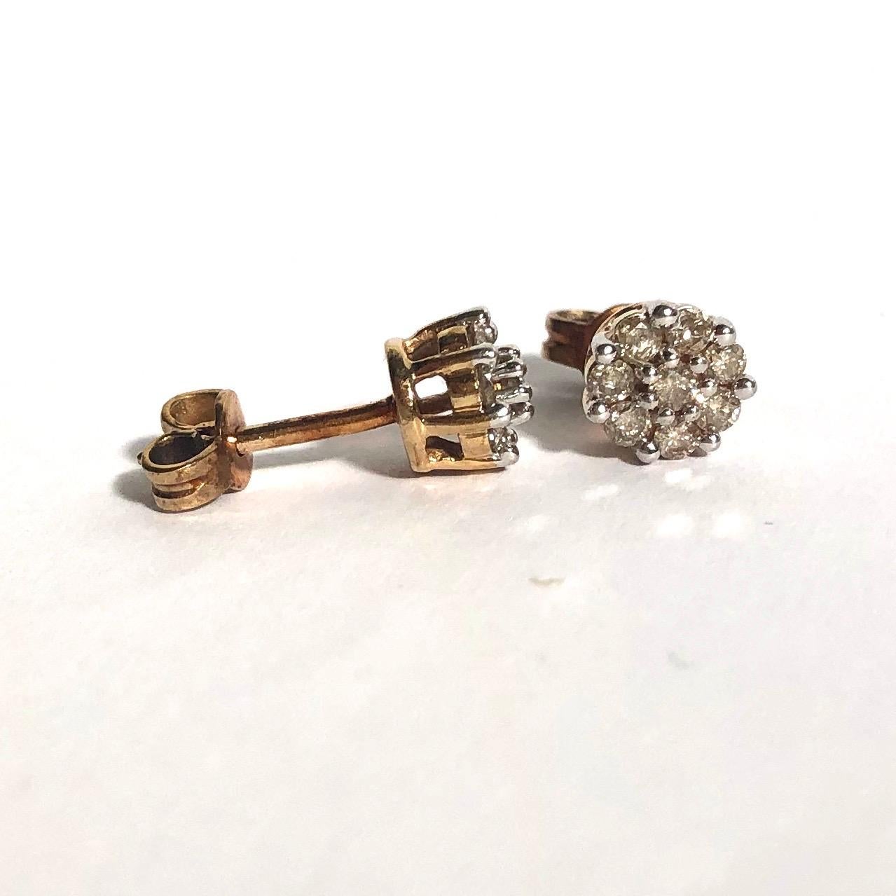 These sparkly diamond cluster earrings hold a total of approximately 15pts of diamonds each. The stones are set in platinum and the rest of the earrings are modelled in 9ct gold. 

Cluster Diameter: 6.5mm 

Weight: 2.04g