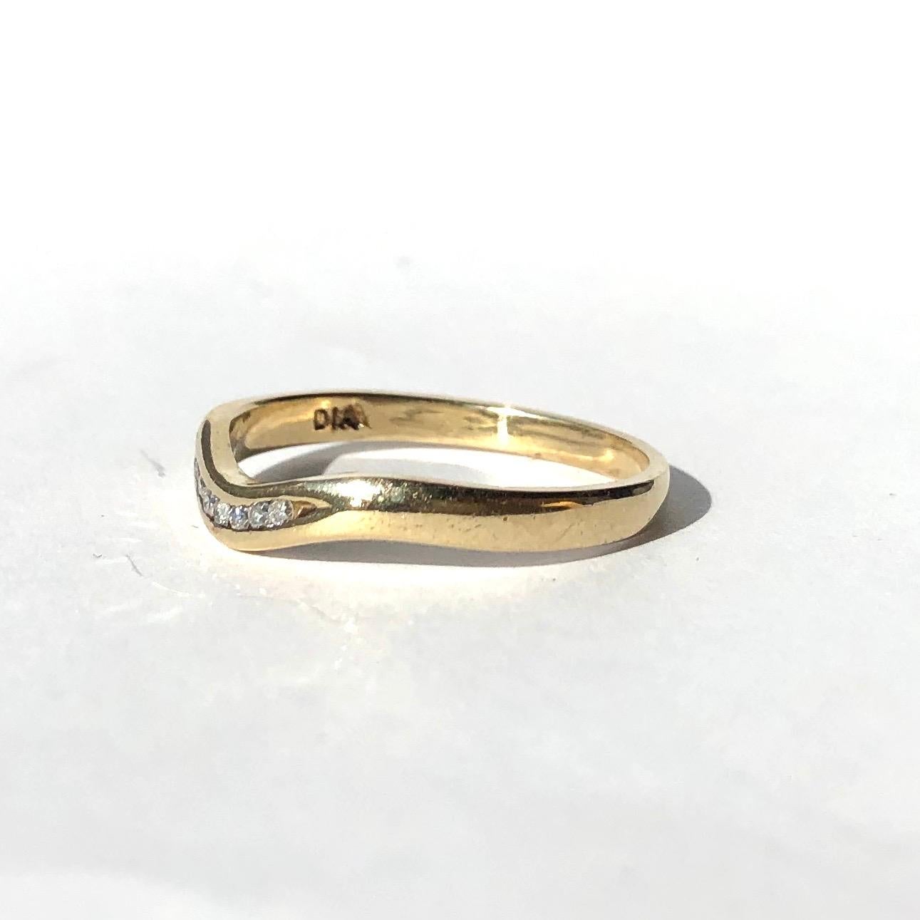 Seven small yet glistening diamonds sit within this 9ct gold band. The stones each measure 1pt and the band has a very subtle 'V' shape to it where the diamonds are set. Made in Birmingham, England. 

Ring Size: P 1/2 or 7 3/4 
Band Width: 2.5mm