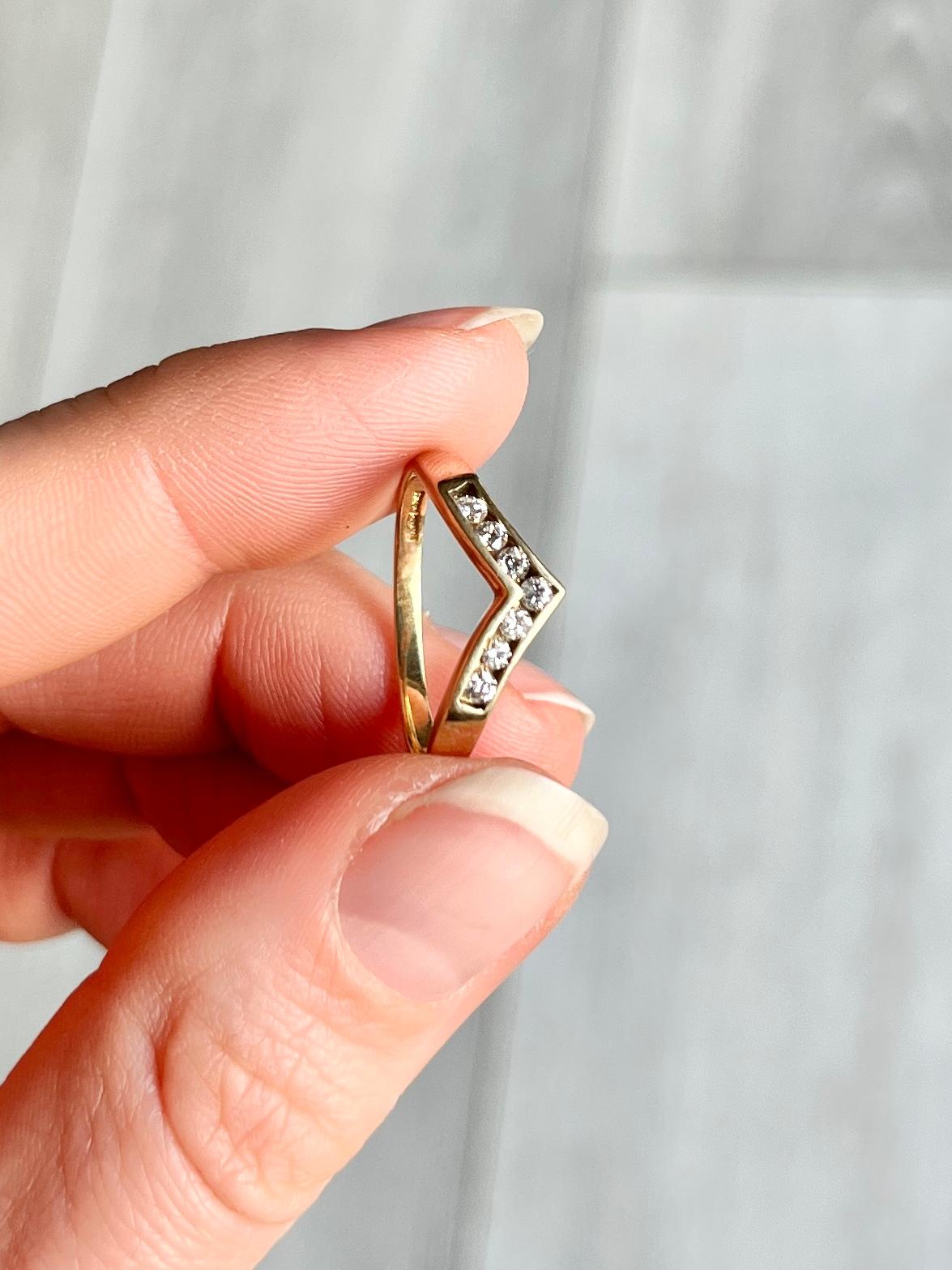 This stylish wishbone ring is modelled in 9carat gold and holds 7 sparking diamonds totalling 14pts. The stones are set in a channel within the band.

Ring Size: M or 6 1/4  
Band Width: 3mm

Weight: 1.6g