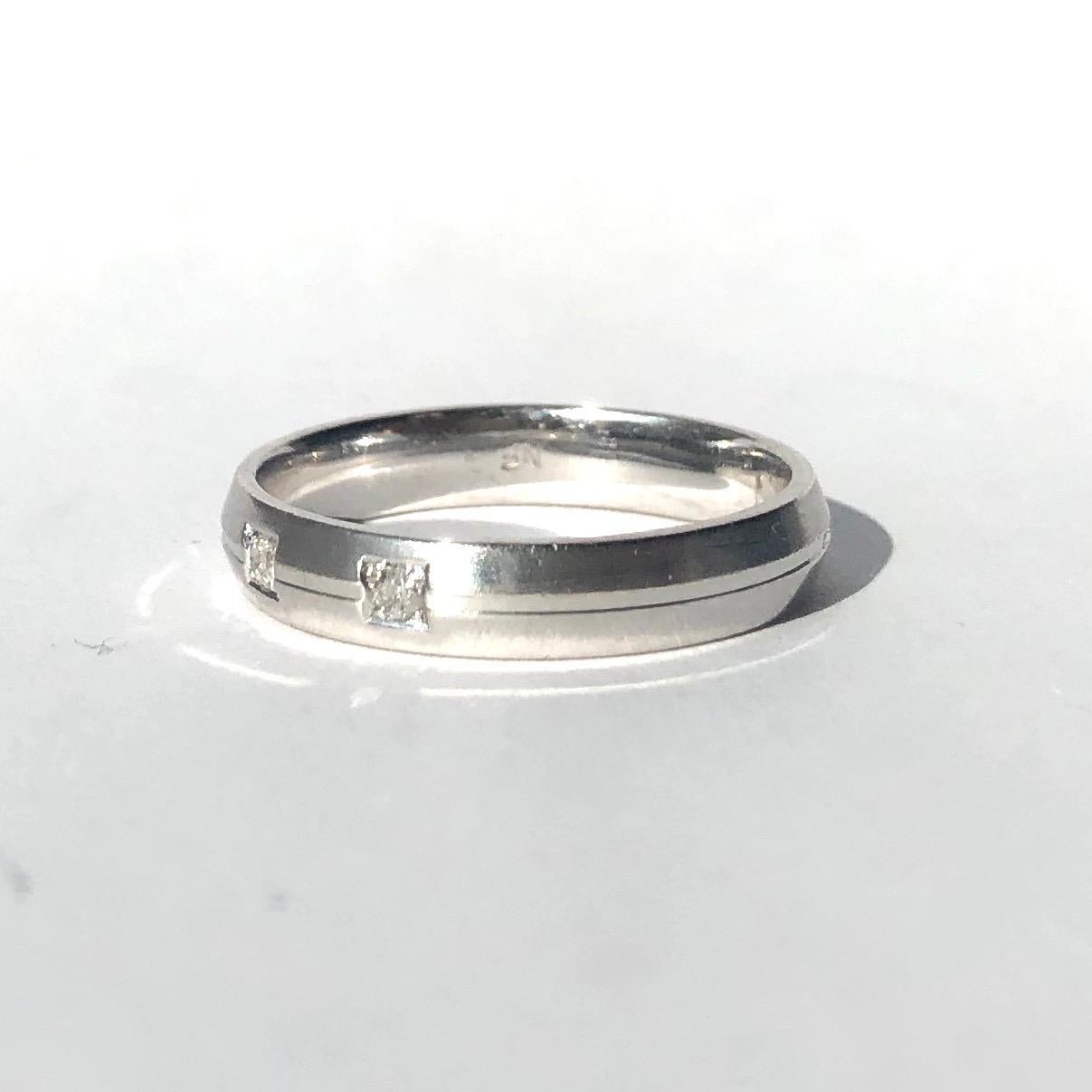 This stylish white gold band has three 5pt diamond set within square settings along with a subtle groove carrying on right the way around the band. The mix of the smooth rounded band with the square settings give this band a modern look. 

Ring