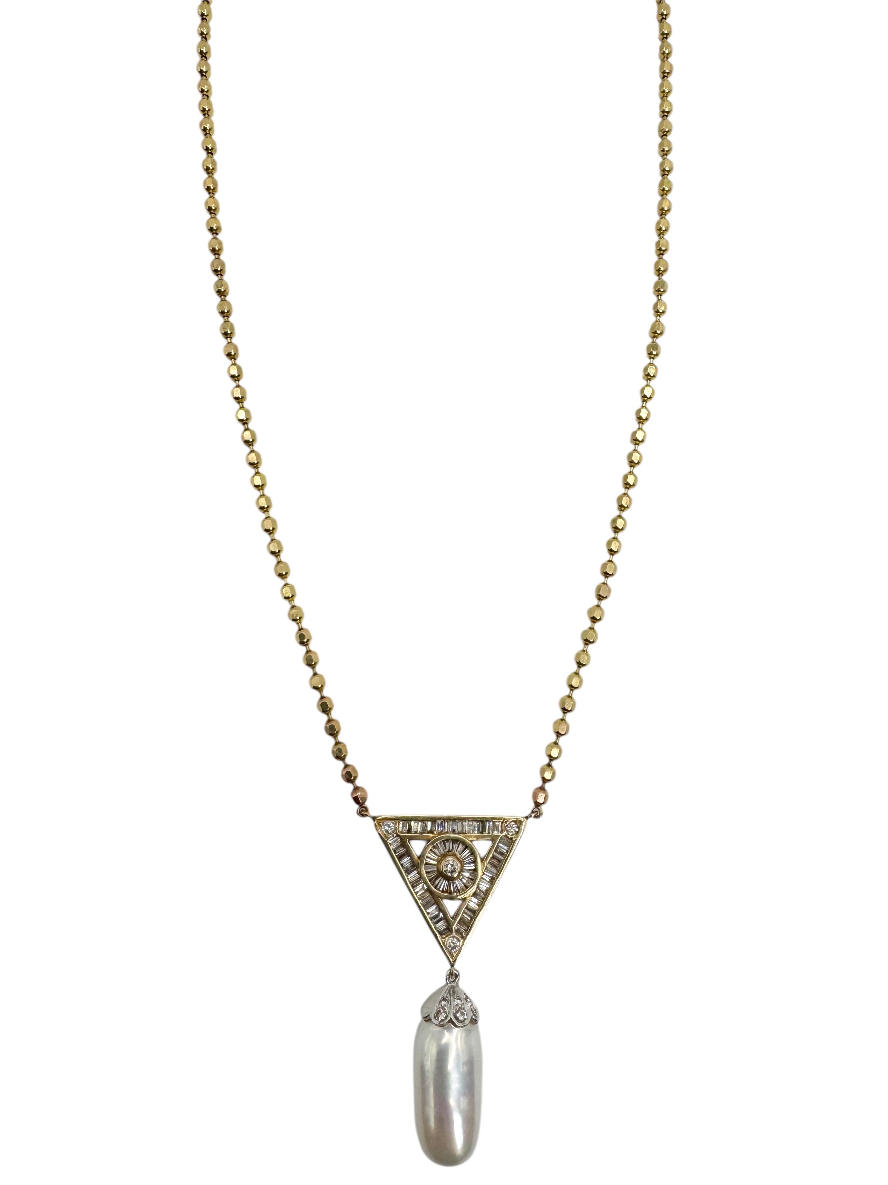 Un'accattivante collana vintage con un artistico ciondolo triangolare con una serie geometrica di diamanti, che sospende una luminosa perla barocca d'acqua dolce. Realizzato in oro giallo 14K, il triangolo traforato è incastonato con 10 diamanti