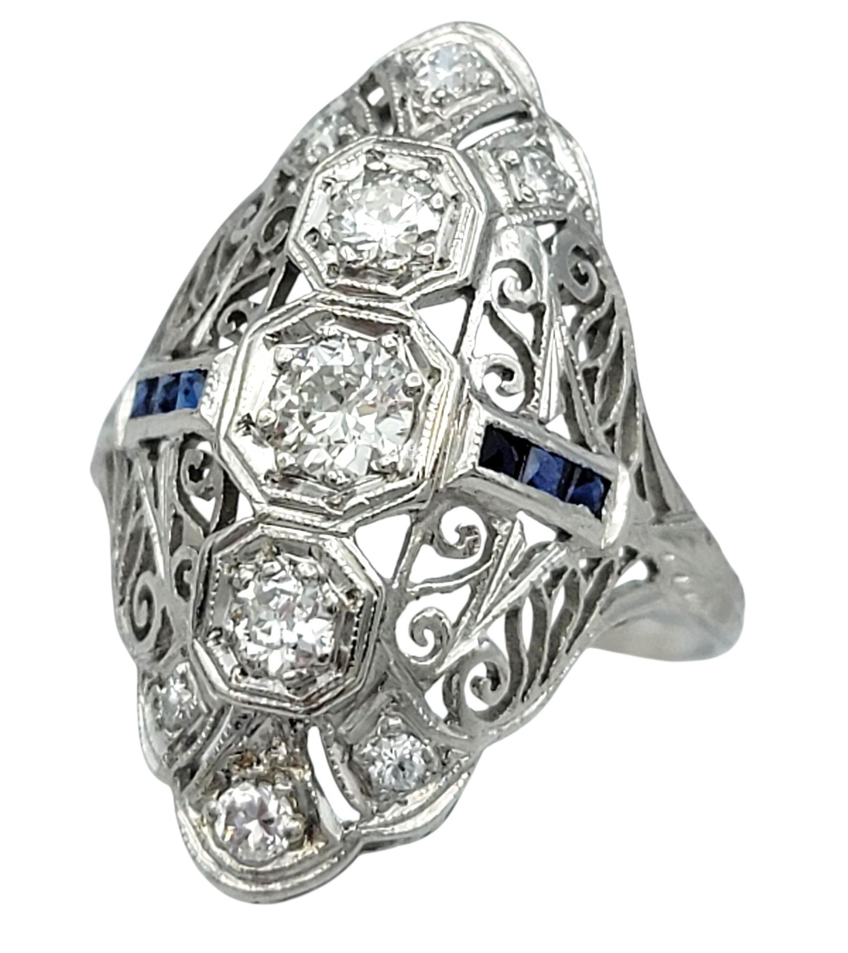 Este anillo vintage de zafiro y diamantes muestra una armoniosa mezcla de elegancia y sofisticación. Elaborado en platino, el anillo presenta una disposición central de diamantes y zafiros, cada piedra meticulosamente engastada para realzar su