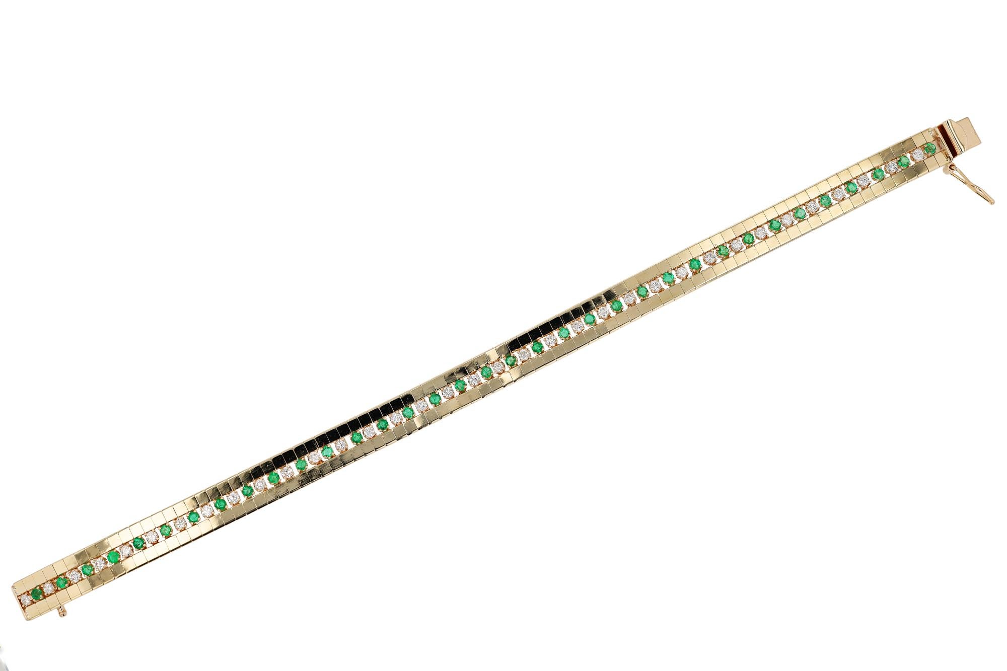 A vintage 1970s beauty! Set with bright and vibrant emeralds alternating with near-colorless diamonds in a straight line motif. Bordering the gemstones are gleaming, polished rows of buttery 14k yellow gold stations that elevate the look. Add a