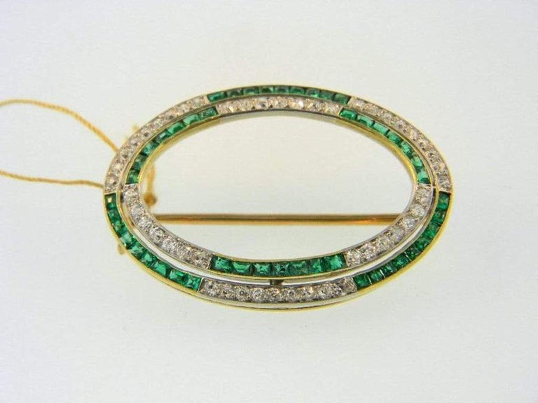 Vintage Art Deco diamond and emerald brooch designed in 18 karat yellow gold and Platinum. The brooch measures 35 x 25mm, two rows of alternating sections of Old European and Old Mine cut diamonds, and square cut Colombian Emeralds. Fine quality