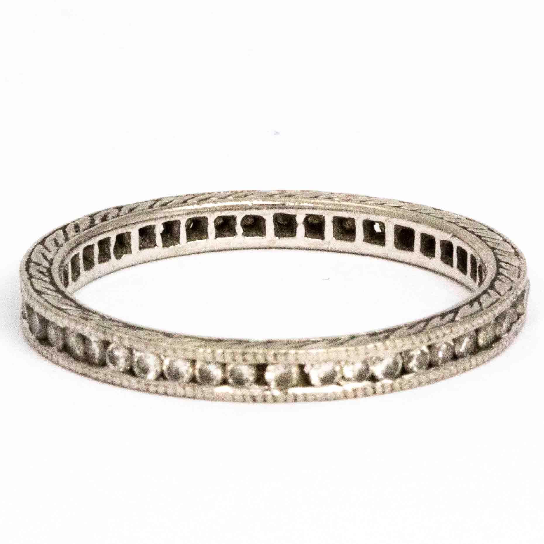 The delicate round diamonds that are encased n this ring measure approximately 1pt each and the band is modelled in platinum. The band itself has wonderful engraving all the way around. 

Ring Size: M or 6
Band Width: 2mm