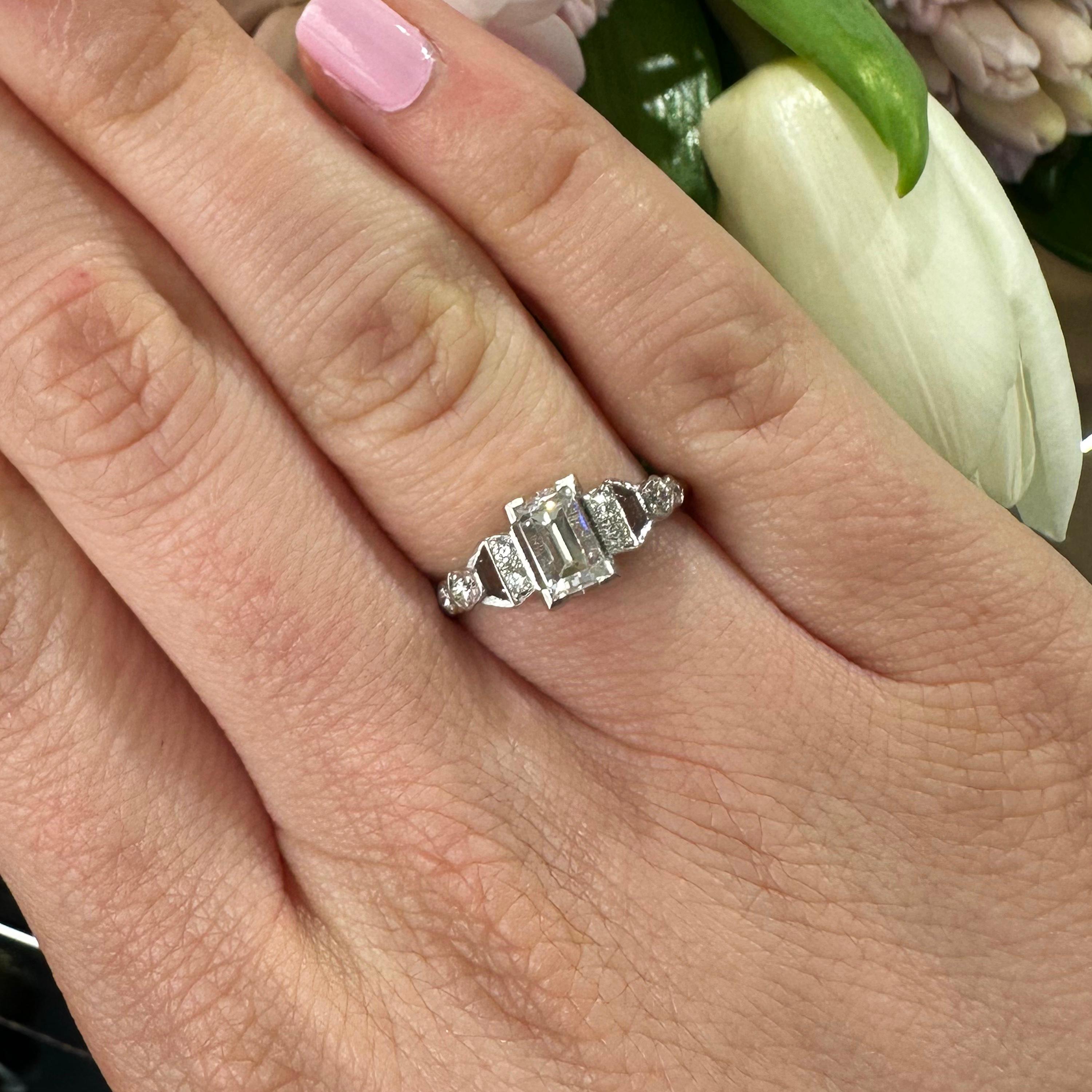 A vintage diamond ring, set with a 0.81ct baguette-cut diamond, accompanied by GCS certificate 5783-622, stating that the colour is F and the clarity is VS2. The centre stone is flanked by eight, round brilliant-cut diamonds, with a total weight of