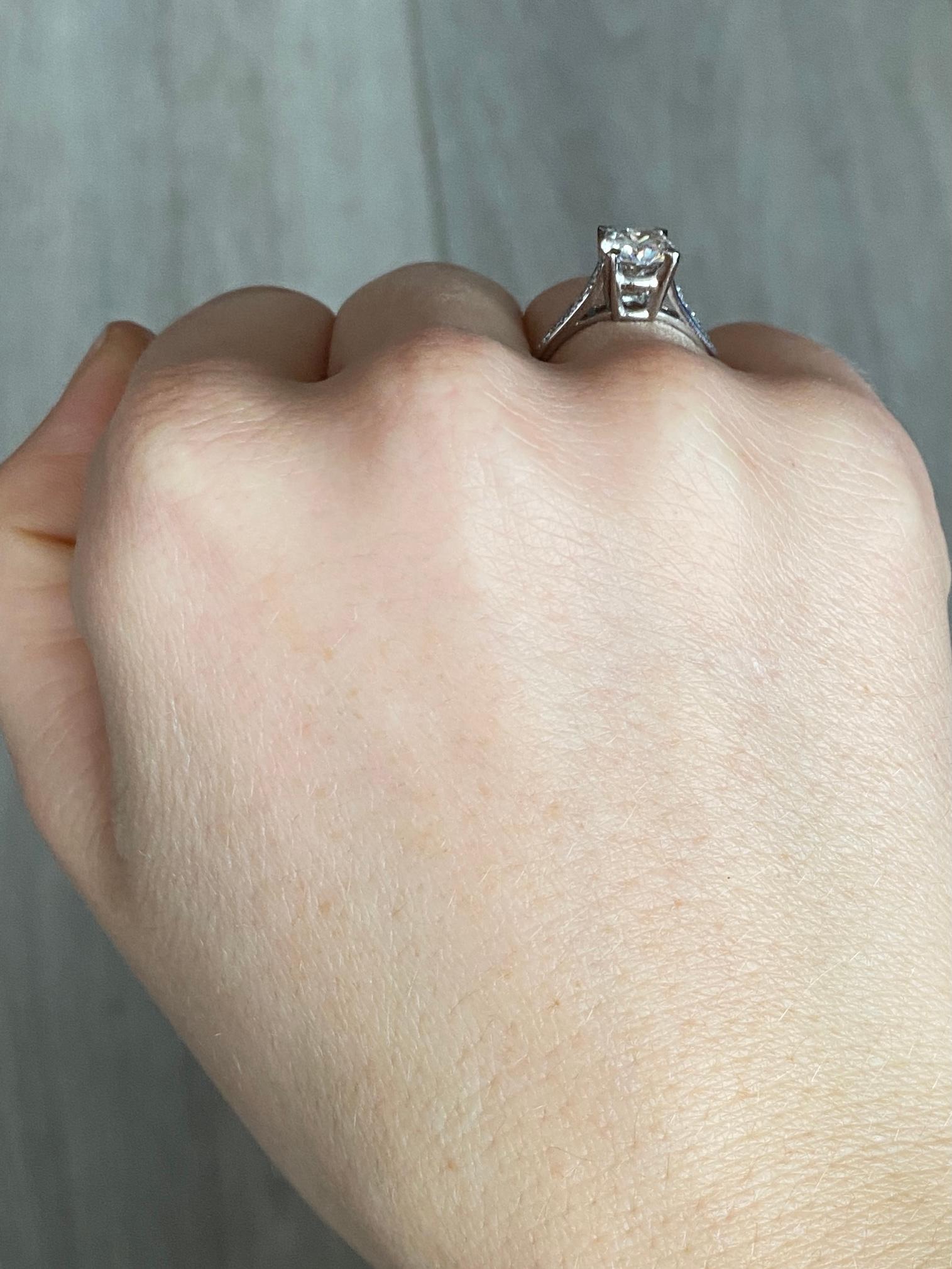 Der Hauptdiamant in diesem Ring misst 1,2 ct und hat die Farbe H/I. Der Stein glänzt wunderschön und an den Schultern sitzen 10 kleine Diamanten. Der Ring ist aus Platin modelliert. 

Ring Größe: N oder 6 3/4 
Höhe ohne Finger: 7mm

Gewicht: 4g
