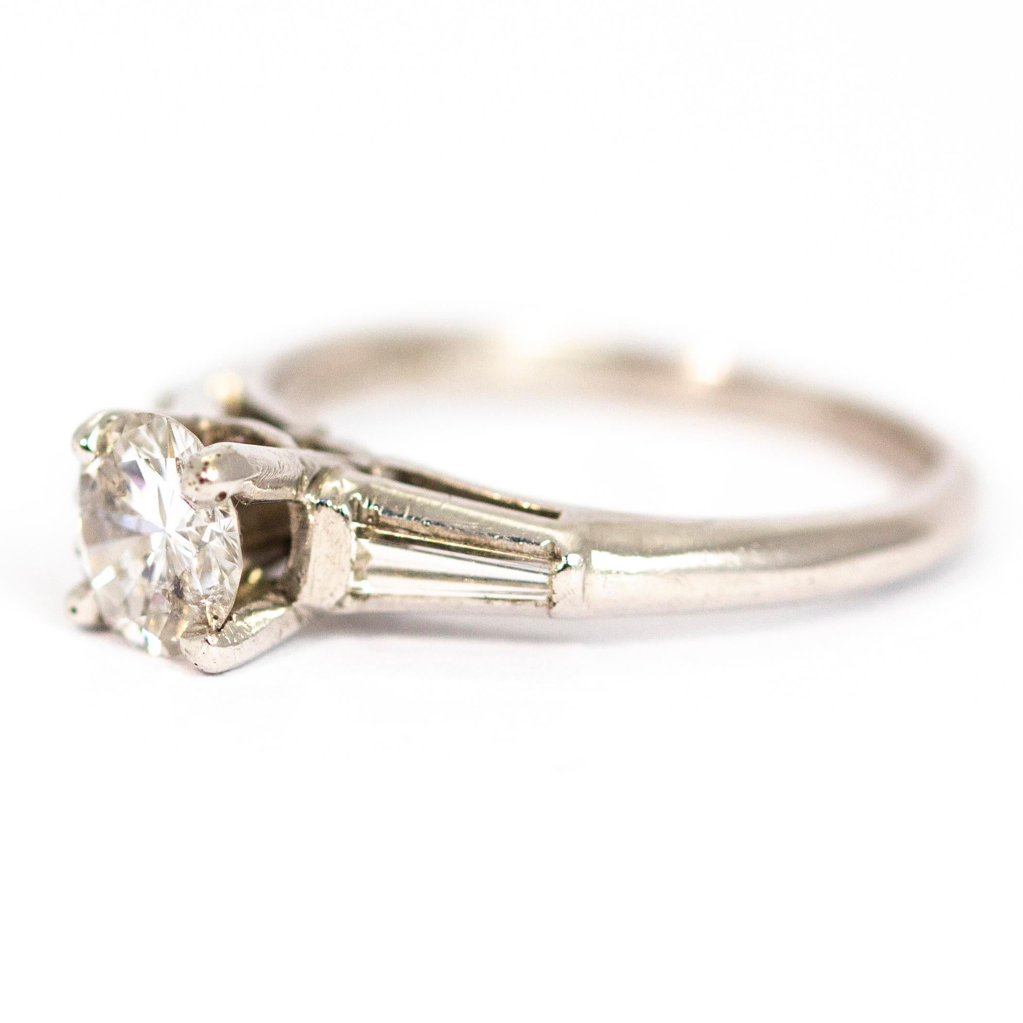 This stunning solitaire holds a 1ct diamond at the centre on top of a heightened open setting. The shoulders hold sparkling tapered baguette diamonds. This would make a stunning engagement ring or a lovely everyday ring to add that little bit of