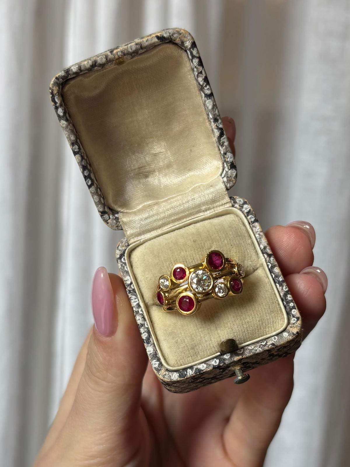 A chunky diamond and ruby bubble ring set in 18k yellow gold .

The ring is composed of three soldered solid yellow gold bands which are scattered with rub over set diamonds and rubies. The setting of the stones gives a bubble like feeling to the