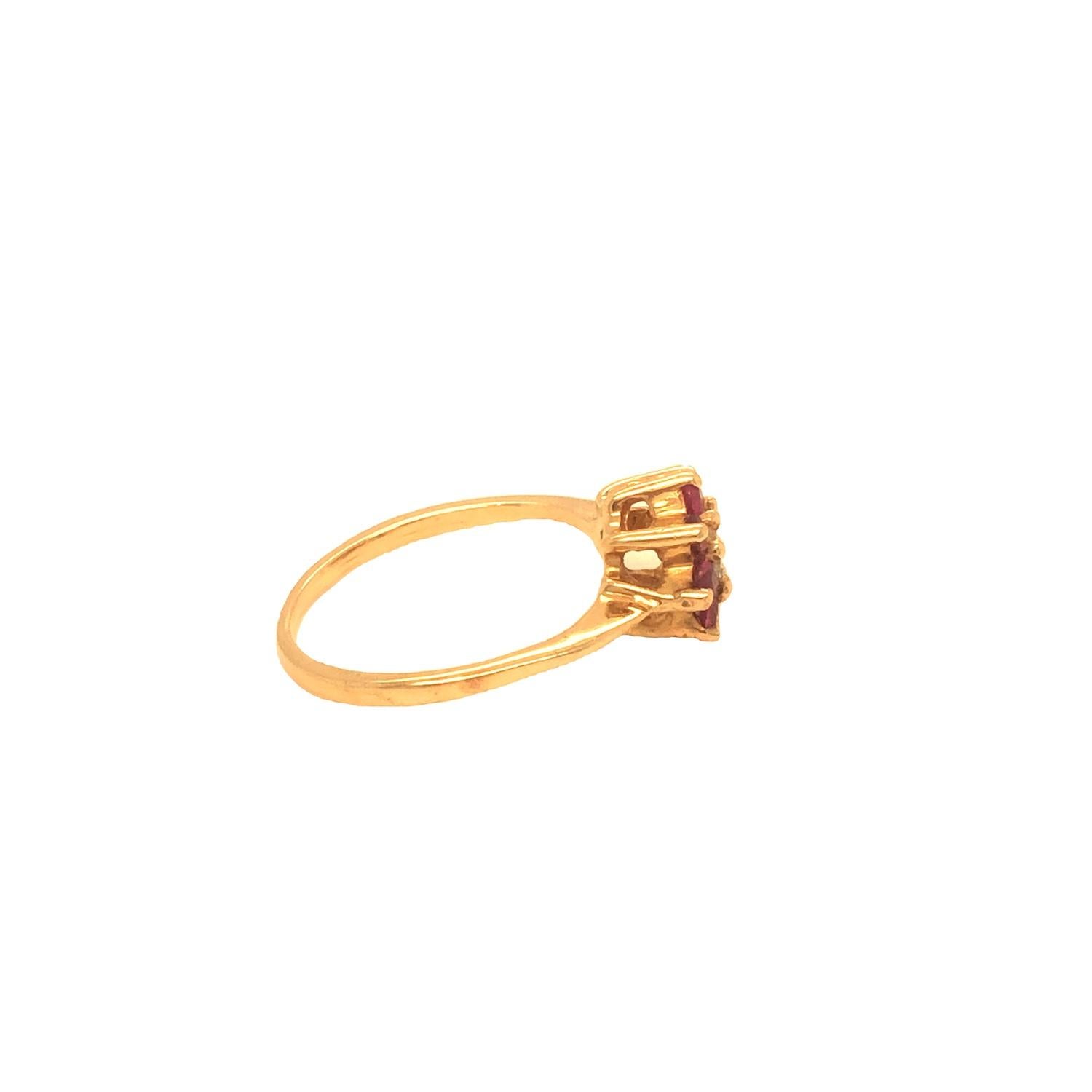 Vintage dainty diamond ring features approximately 0.25 carat center stone. The diamond is encircled with eight rubies weighing approximately .24 carat. The ring is crafted in 14K yellow gold. Currently size 5 (resizable).