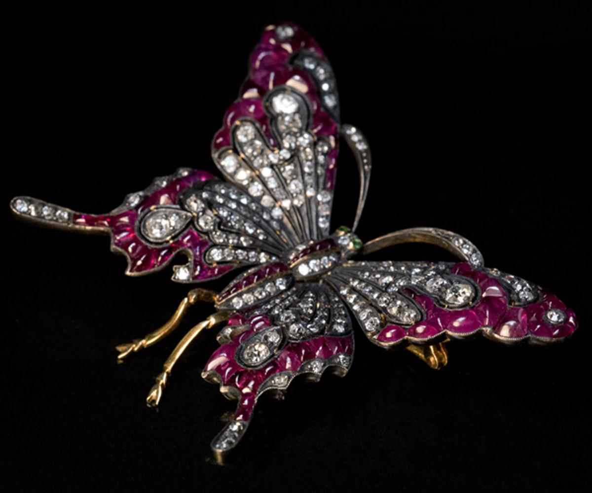 This Austrian mid-century (c.1950s-1960s) large butterfly brooch is designed in Belle Epoque style of the early 1900s. The butterfly is superbly crafted in silver and 18K gold and is set with old cut diamonds and cabochon calibre cut natural rubies,