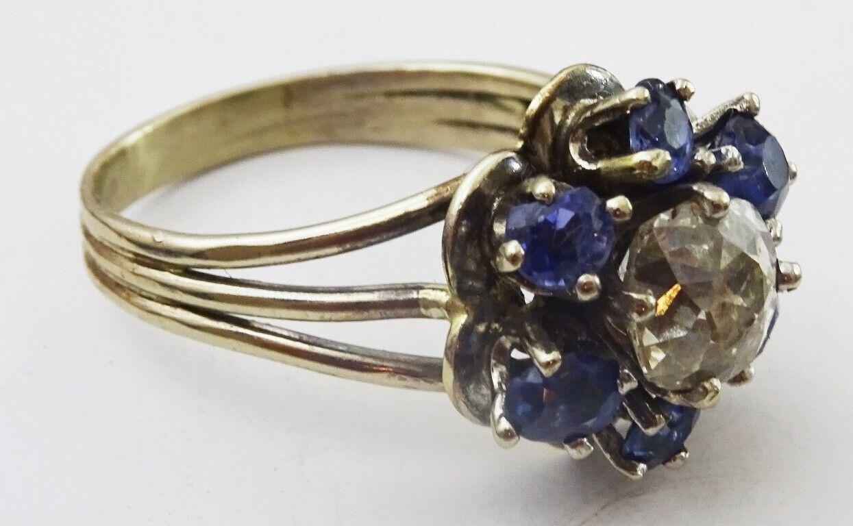 
We have here for sale a acid tested 14 karat Gold Ring.
the style of the ring and the cut of the stones tell us that this ring is from the first quarter of the 20th century.
It is a flower cluster Ring , in the center there is a rectagularish 90