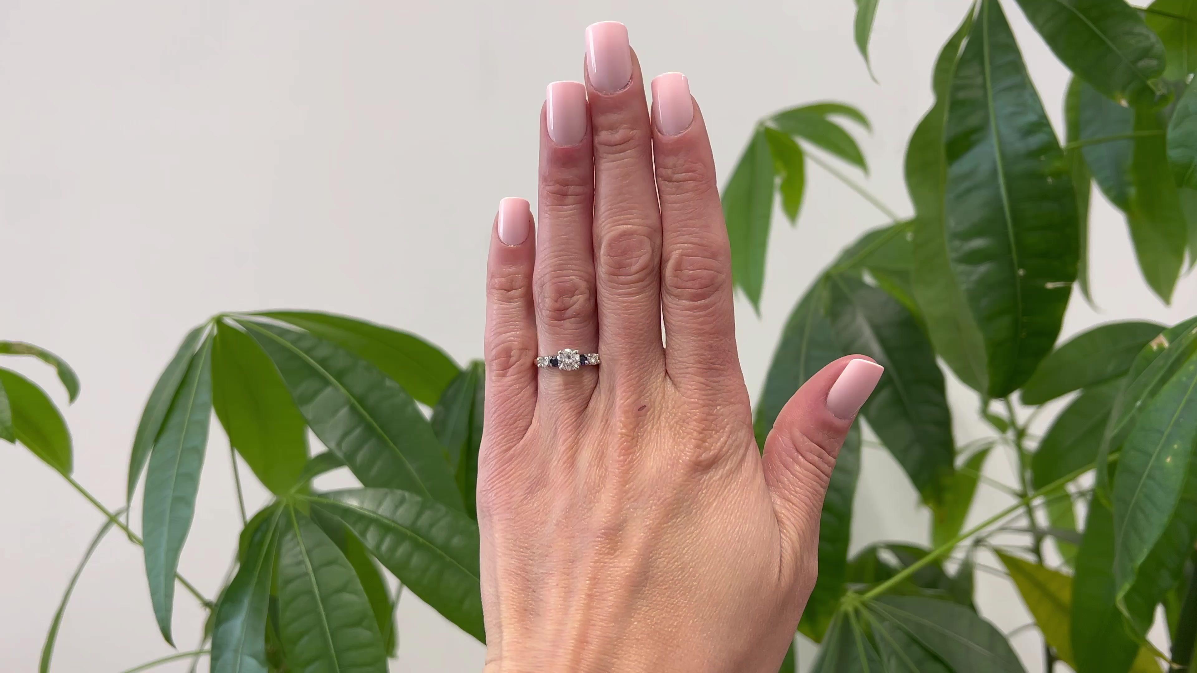 Ein Vintage Diamant und Saphir 14k Zwei-Ton-Ring. Mit einem runden Diamanten im Brillantschliff mit einem Gewicht von ca. 0,65 Karat, eingestuft in Farbe F und Reinheit SI1. Akzentuiert durch zwei runde Saphire im Brillantschliff mit einem