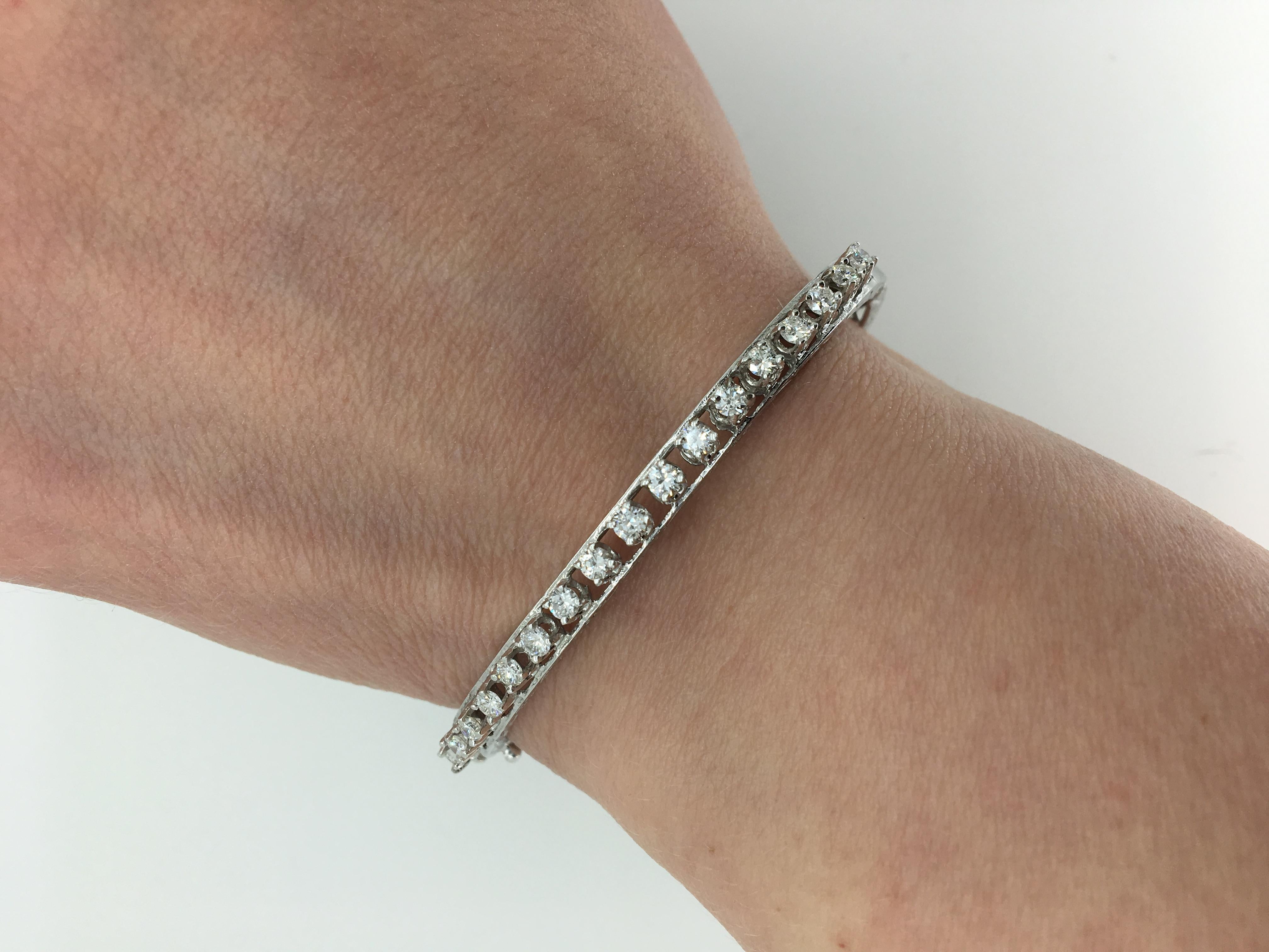 This bangle style bracelet features 17 Round Brilliant Cut Diamonds displaying an average color of F-H and an average clarity of VS1-SI1. There is approximately 1.10CTW prong set along the 14K white gold bracelet. This handcrafted bangle is