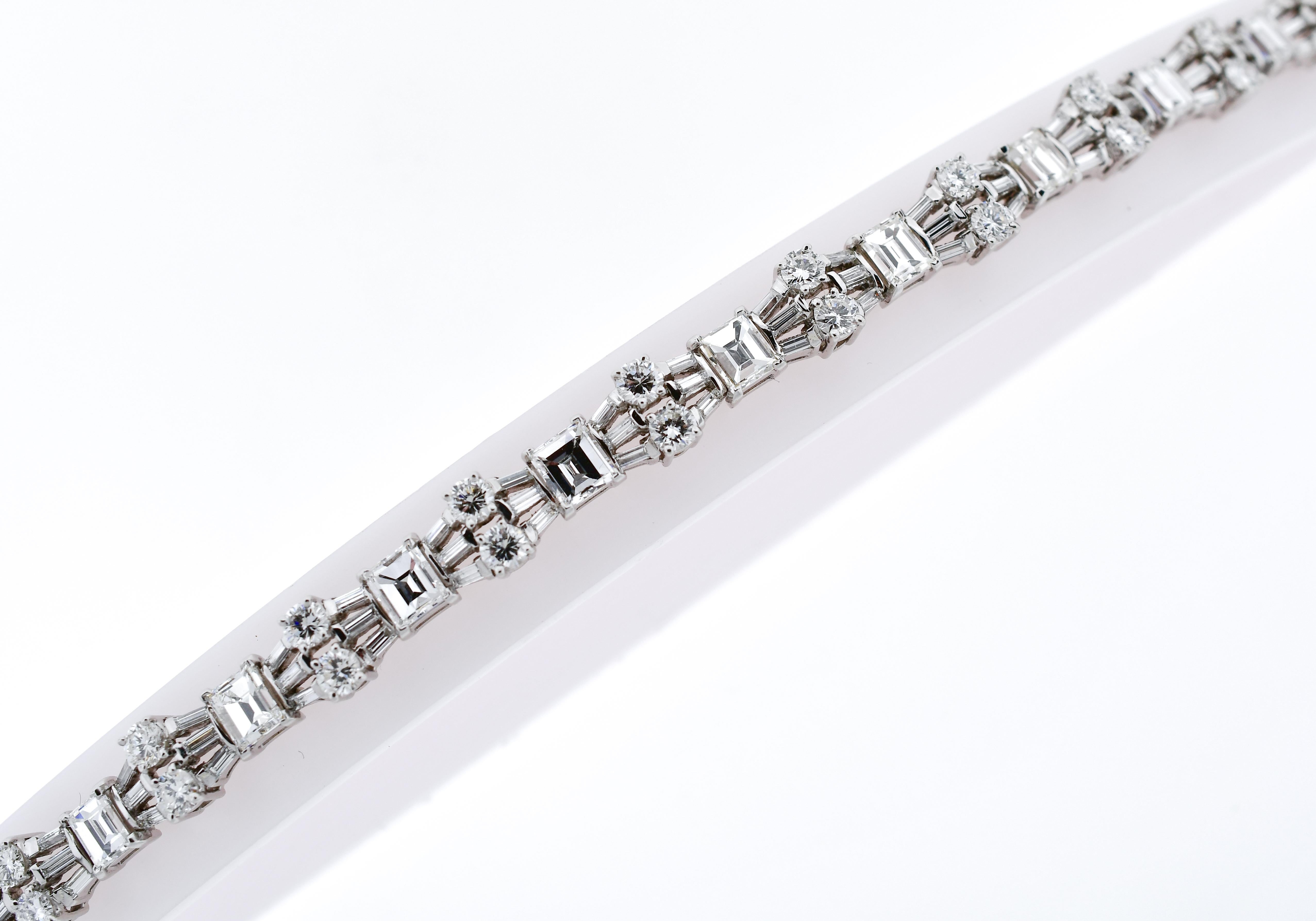 Exquisitely made in platinum, hand finished straight-line bracelet composed with thirteen (13) rectangular step cut diamonds, twenty six (26) round brilliant cut diamonds, and seventy eight (78) baguette cut diamonds, totaling 14.00 carats - 15.00