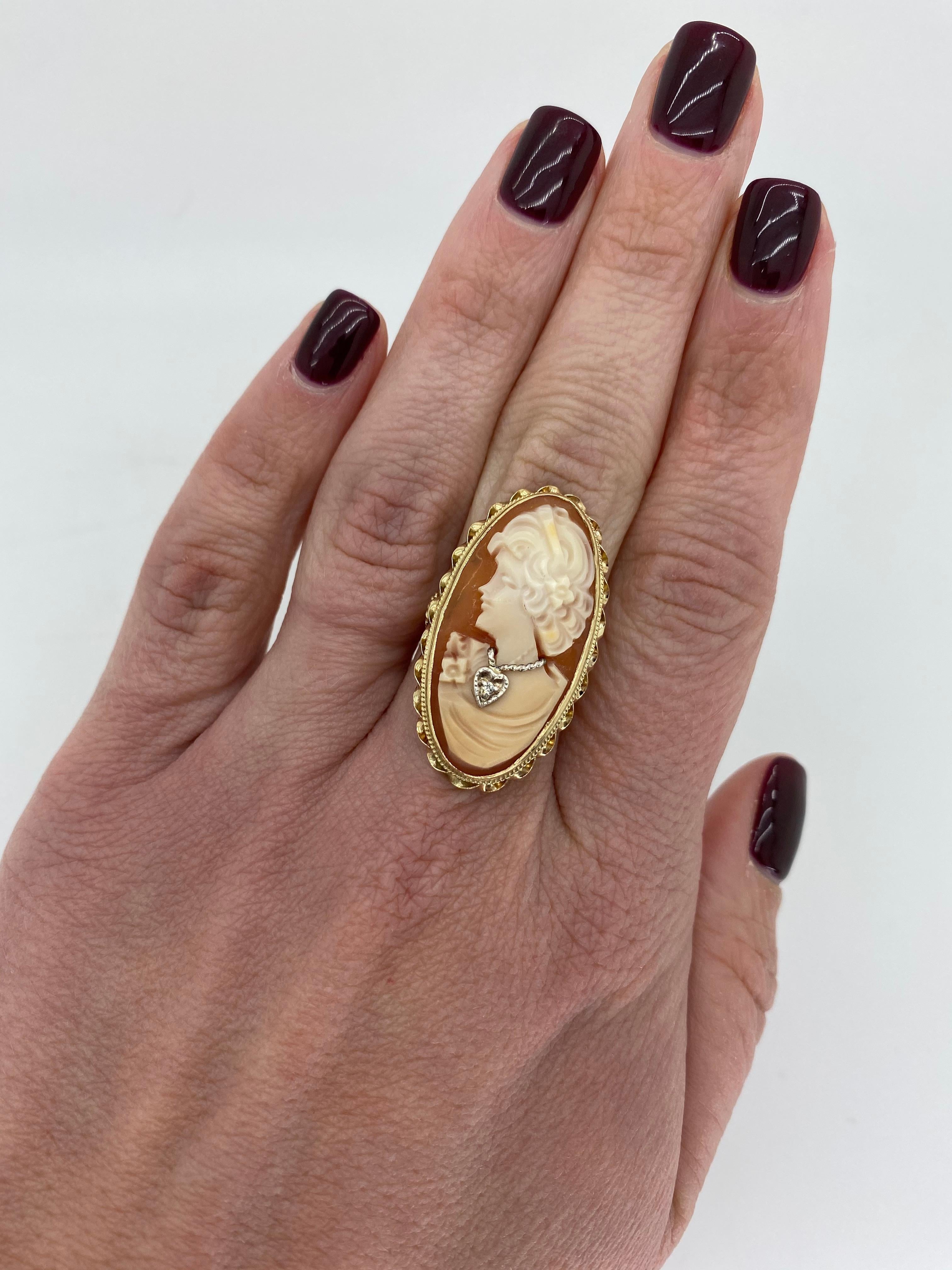 Vintage Cameo ring with a diamond accent crafted in 14k yellow gold. 

Cameo: Approximately 33x19mm 
Diamond Carat Weight:  Approximately .0025CTW
Diamond Cut: Old European Cut
Color: G-I
Clarity:  SI
Metal: 14K Yellow Gold
Marked/Tested: Tested 14K