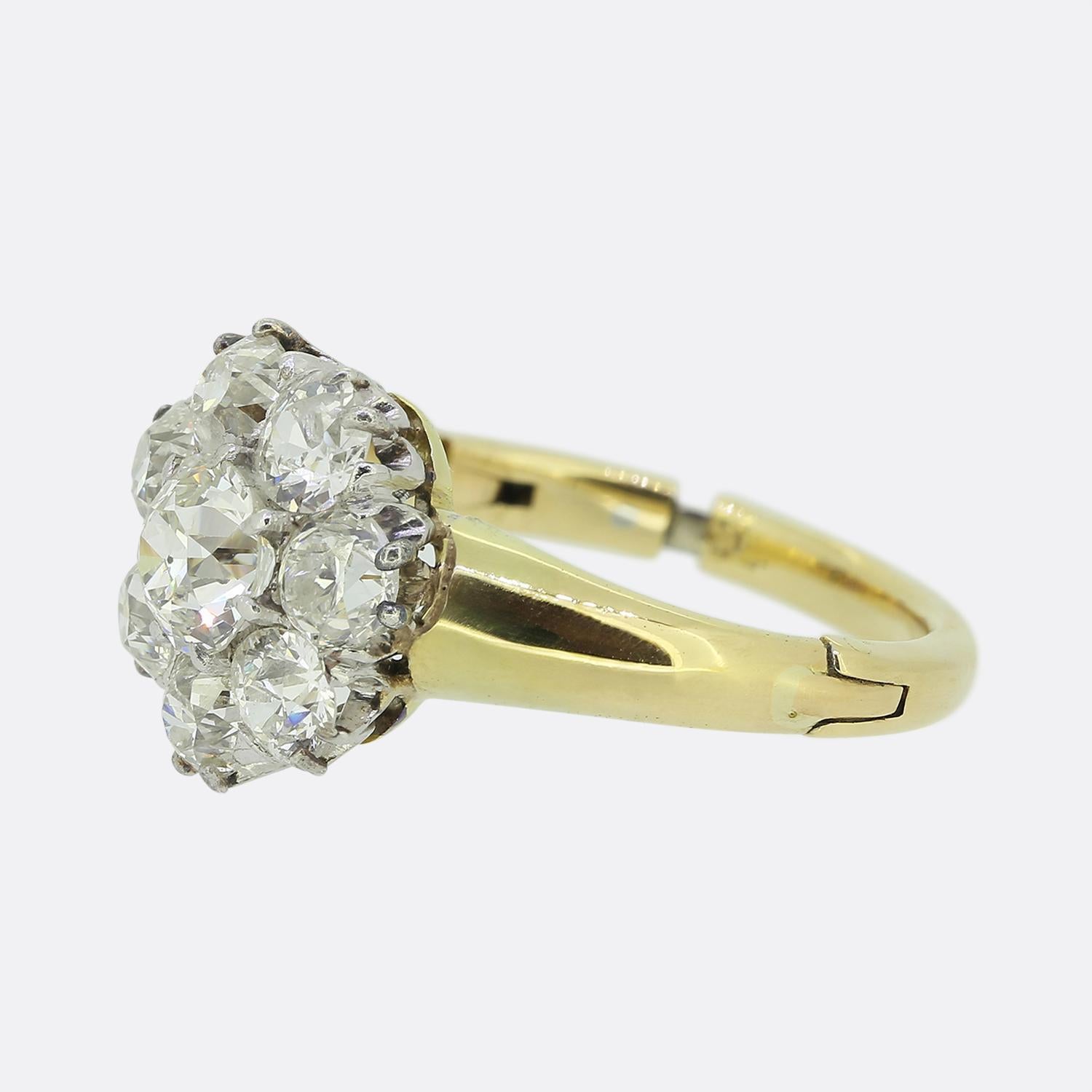 Hier haben wir einen entzückenden Diamant-Cluster-Ring. Dieser Vintage-Ring wurde aus 18 Karat Gelbgold gefertigt und weist einen einzelnen runden, facettierten Diamanten mit altem Minenschliff in der Mitte der Vorderseite auf. Dieser Hauptstein