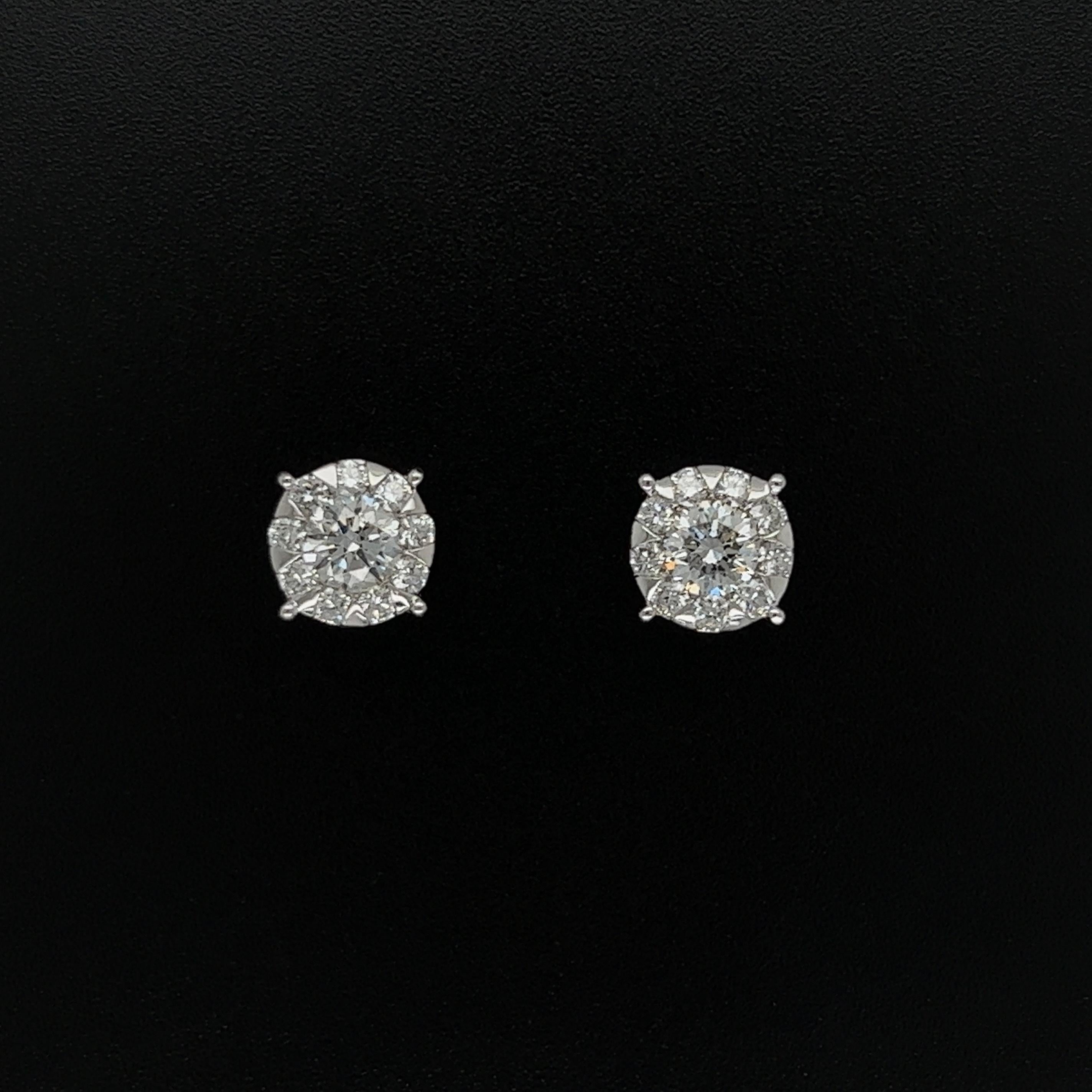 Simply Beautiful! Pair of round Diamond Cluster Gold 7.4mm Stud Earrings. Securely nestled and Hand set in 18 Karat white Gold four-claw setting. Diamonds weighing approx. 1.03tcw. Measuring approx. 0.65”L x 0.35”W x 0.85”H x 0.35” h. These earrings