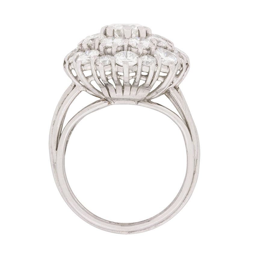 A vintage cluster ring, which boasts a centre stone of 0.50 carat and the surrounding round brilliants totalling 2.80 carat. The colour is graded F and the clarity VS2 which becomes apparent through it's shine and sparkle. The diamonds are claw set,