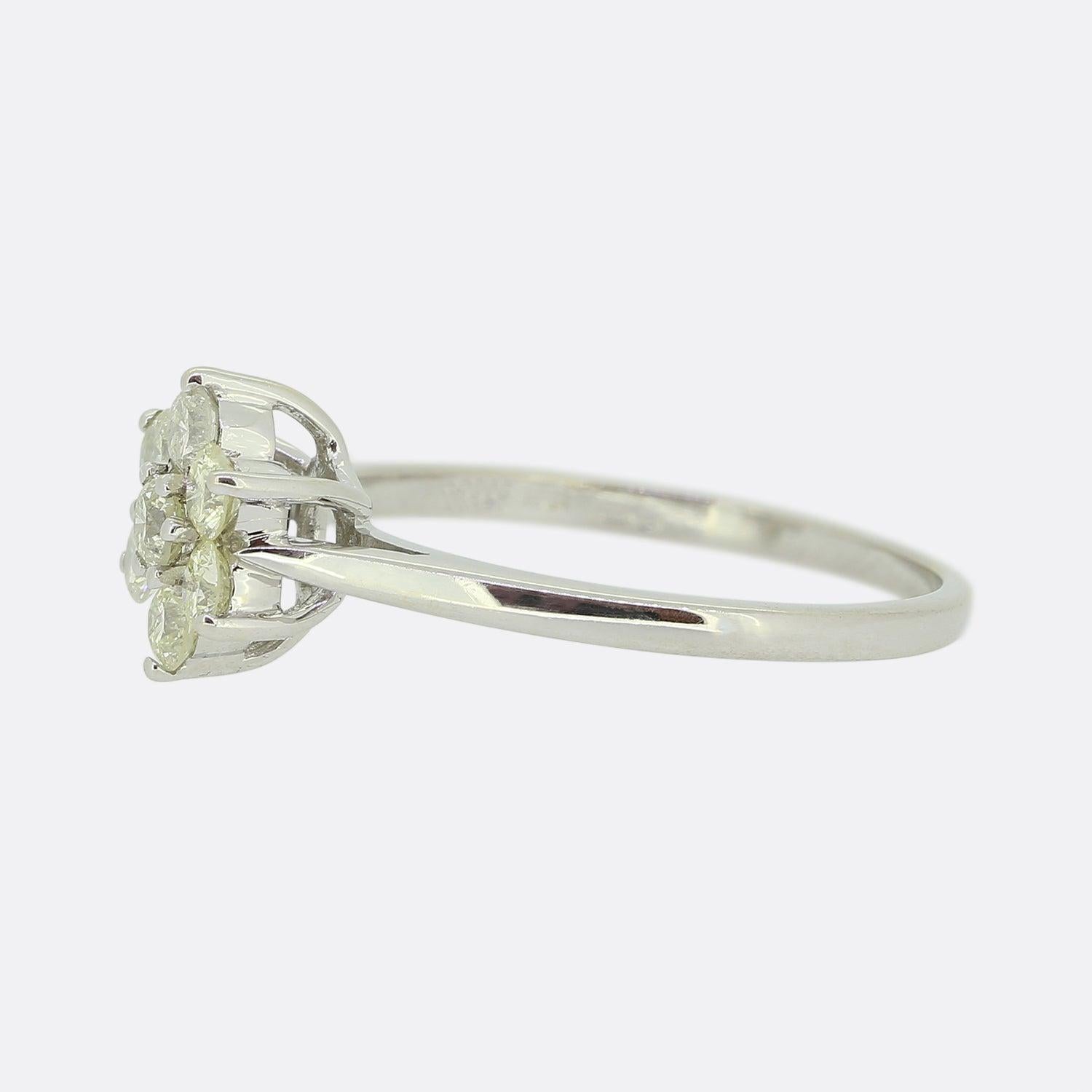Here we have a delightful vintage diamond cluster ring. An 18ct white gold mount plays host a daisy cluster of round brilliant cut diamonds; each of which has been individually claw set and collectively sit atop a plain polished shank. 

Condition: