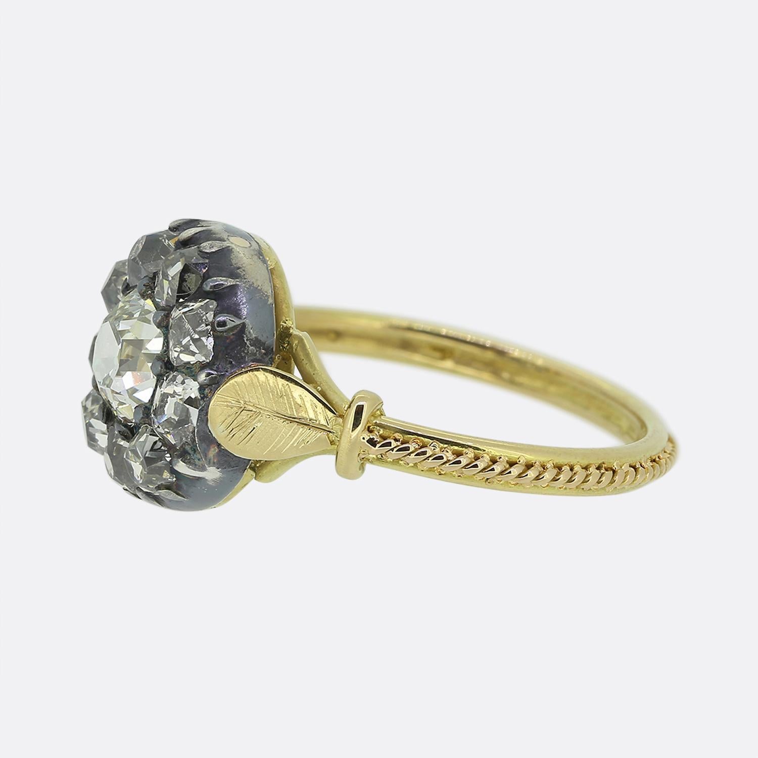 Here we have a stunning diamond cluster ring originally dating back to the Victorian period. A fabulously chunky old cushion cut diamond sits slightly risen at the centre of the face and is surrounded around the outer edge by a circulating array of