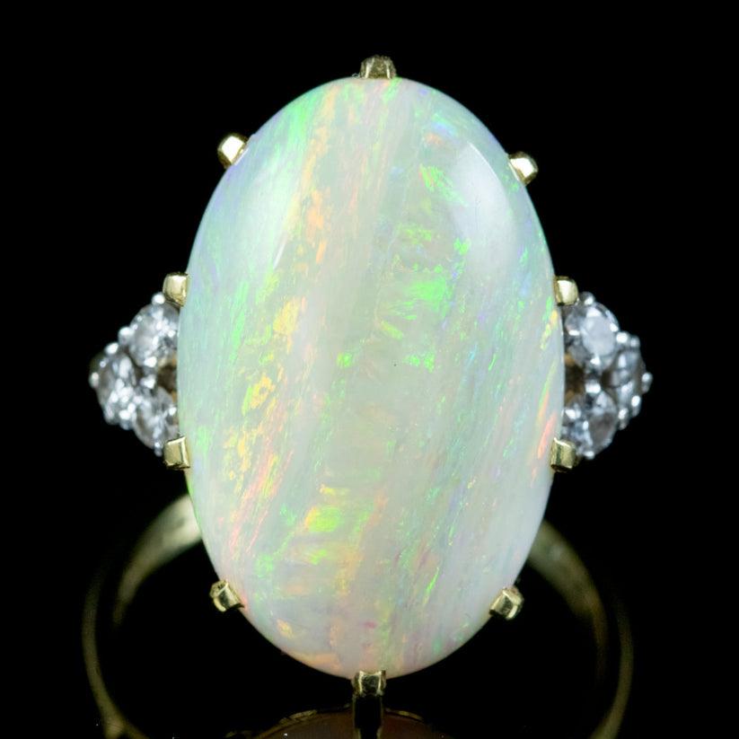 A spectacular 1970s cocktail ring boasting a magnificent natural opal cabochon weighing approx. 25ct. The stone is a kaleidoscope of rainbow colours shimmering and changing colours with the light. It radiates blues, pinks, greens and an inner orange