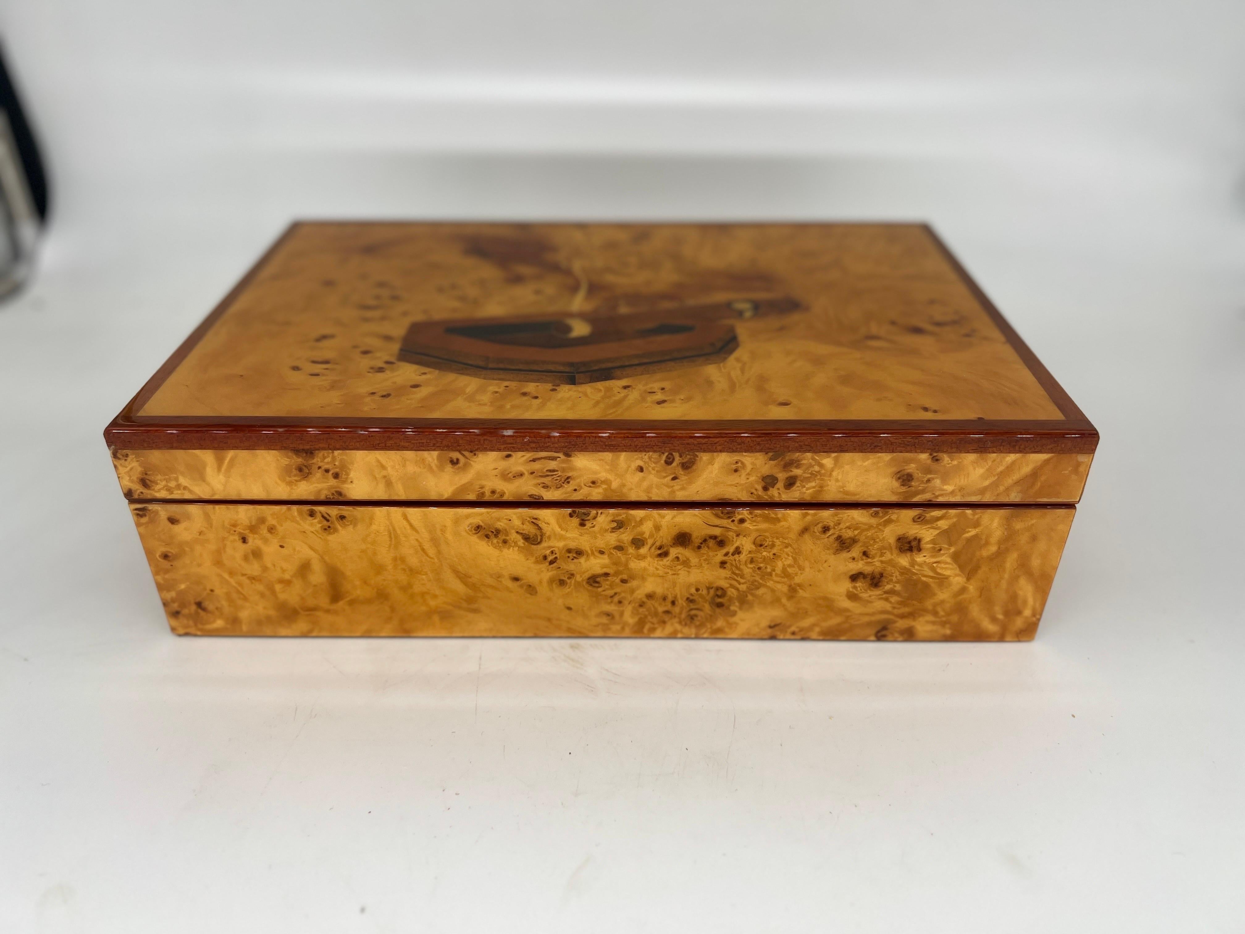 This vintage Diamond Crown inlaid burl-wood humidor is the perfect addition to any cigar lover's collection. With its intricate design and high-quality craftsmanship, it is sure to impress. The humidor is designed to keep your cigars fresh and in