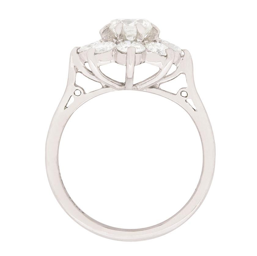 This beautiful daisy cluster ring has a total weight of 1.72 carat. The centre round brilliant diamond weighs 0.62 carat, this is confirmed by a stamp on the inside of the band, and the eight surrounding each weigh 0.10 carat. All the diamond match