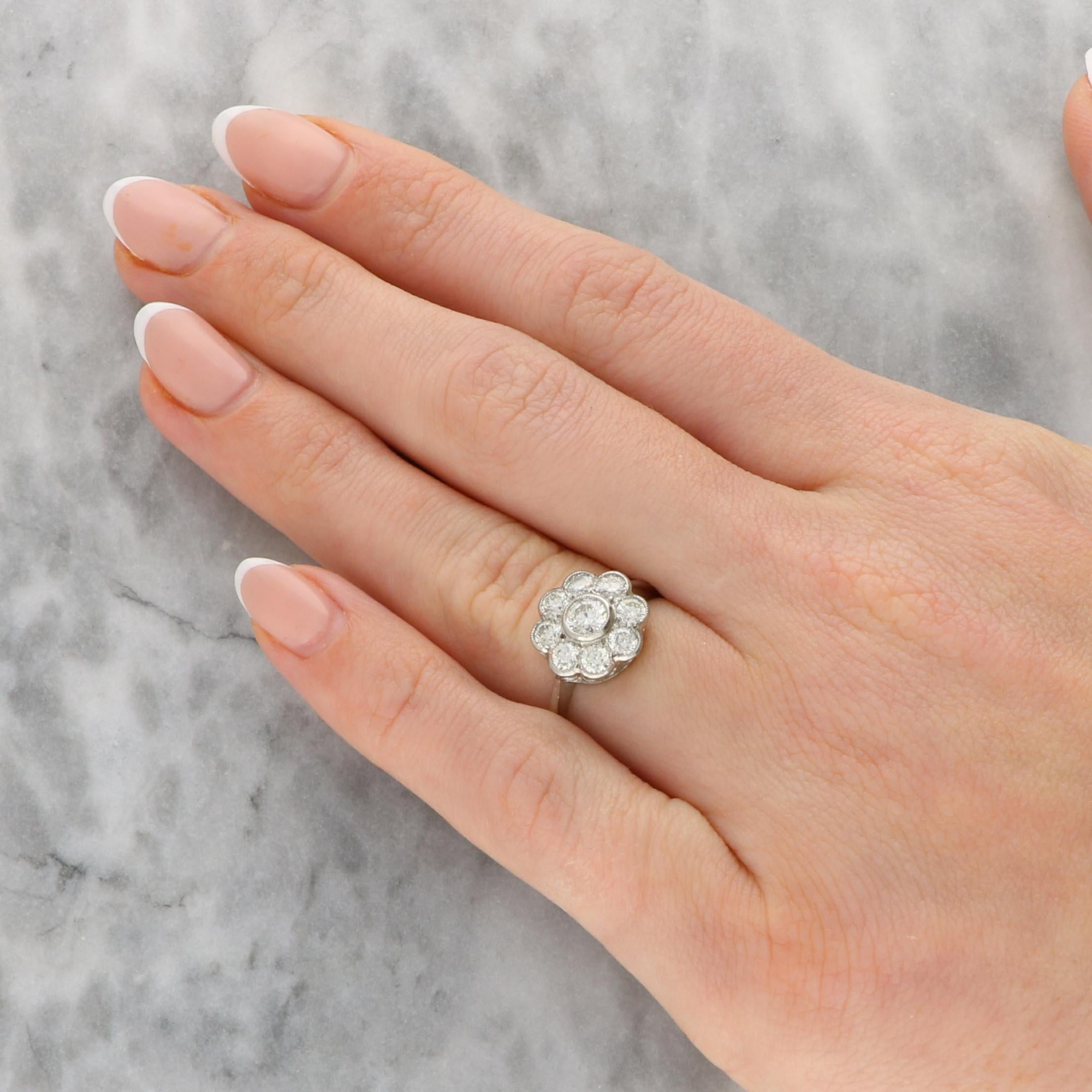 Ein wunderschöner Vintage-Diamantring mit Gänseblümchen, gefasst in Platin. 

Das Schmuckstück besteht aus 9 runden Diamanten im Brillantschliff in einer traditionellen Gänseblümchenfassung. Der zentrale Diamant ist leicht erhaben, während die