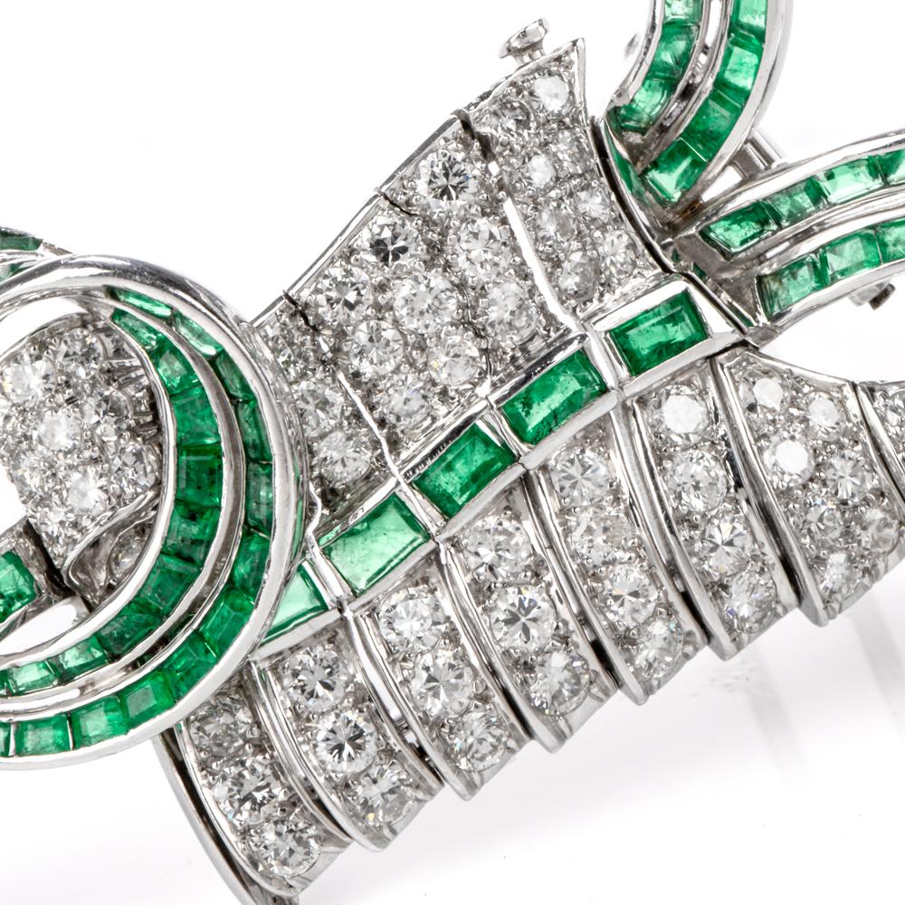 This artistic vintage diamond and emerald brooch is crafted in solid platinum, weighing 35.4 grams and measuring 2.75” long x 51mm wide. Pave-set with 75 round-cut diamonds, collectively weighing approximately 5.10 carats, graded G-H  color and