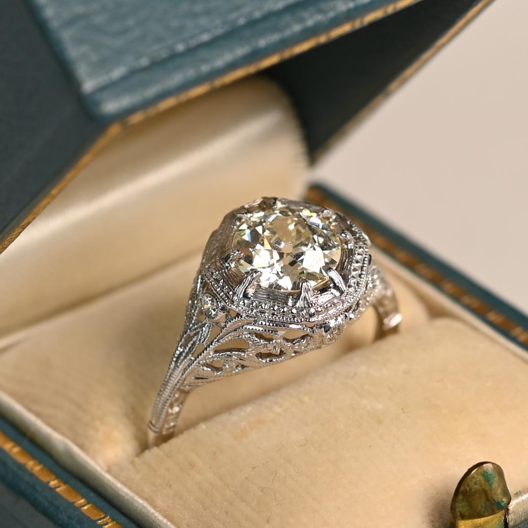 Questo squisito anello di fidanzamento con diamante vintage mette in mostra uno splendido diamante antico di taglio europeo, del peso di circa 1,2 carati. Il diamante, classificato L per il colore e VS2 per la purezza, irradia una bellezza senza