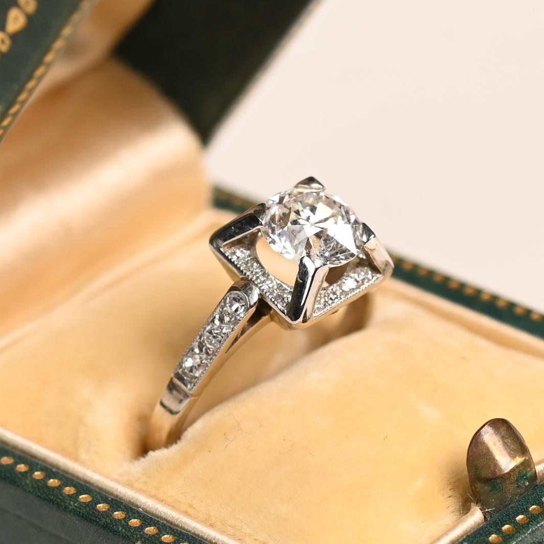 Questo splendido anello di fidanzamento vintage con diamante francese di epoca retrò presenta un vivace diamante di taglio europeo antico del peso di 1,42 carati, di colore E e purezza SI1. Il diamante centrale è elegantemente incastonato in