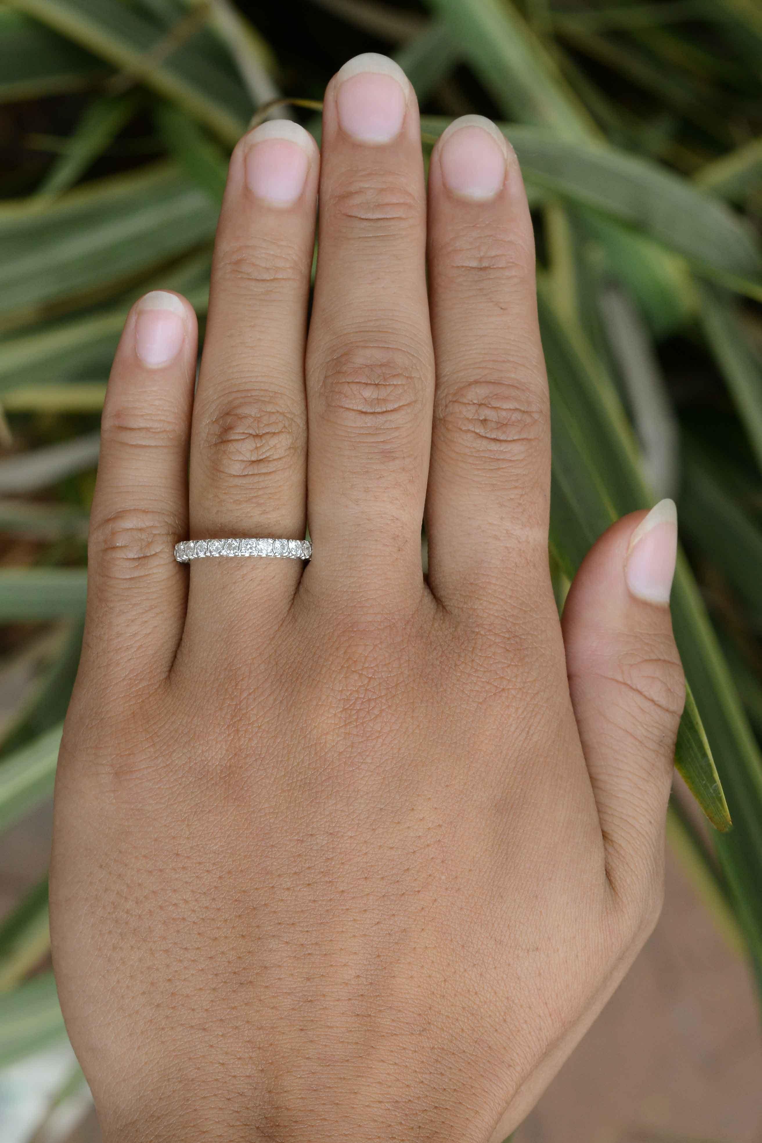 A stunning, vintage 1 carat diamond eternity band. This estate wedding band is set with 24 white diamonds of exceptional clarity and brilliance that completely encircle this bridal jewel. The low, prong setting is quite comfortable and can be worn