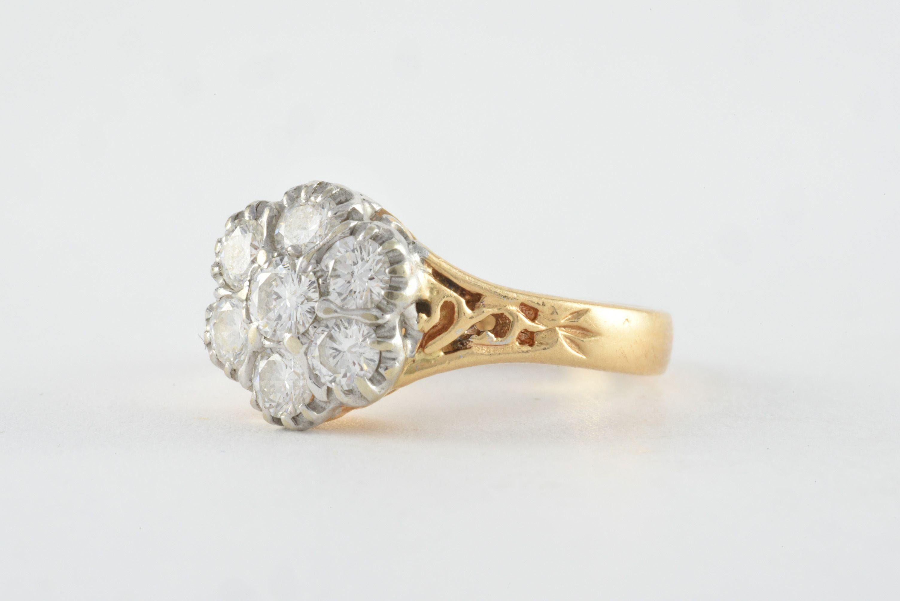 Seven bright white round brilliant-cut diamonds totaling approximately 0.70 carats, G color, VS clarity set in a floral design adorn this vintage band crafted in 14kt yellow gold and embellished with decorative piercing. 