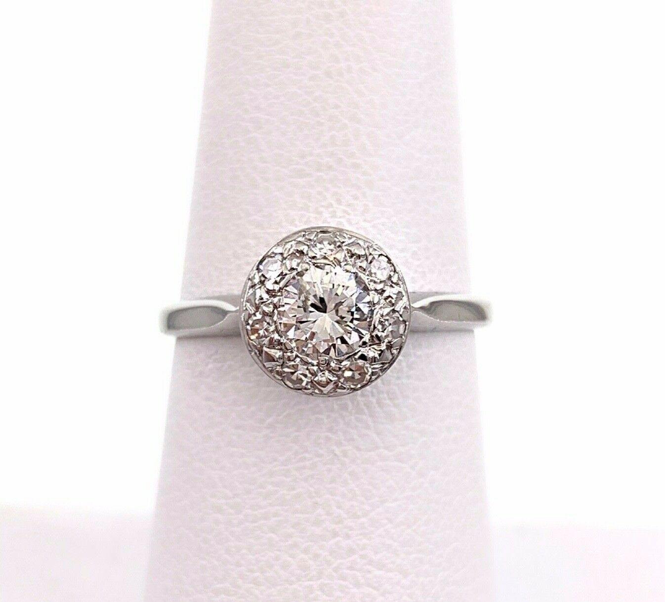 Vintage Diamond Ring
Style:  Diamond Halo Engagement Ring
Era:  1940's
Metal:  14K White Gold
Size / Measurements: 6.5, sizable
TCW:  0.60 carats total
Main Diamond: 0.45 carat Round Brilliant Cut
Accent Diamonds:  7 Single Cut Diamonds
Color &