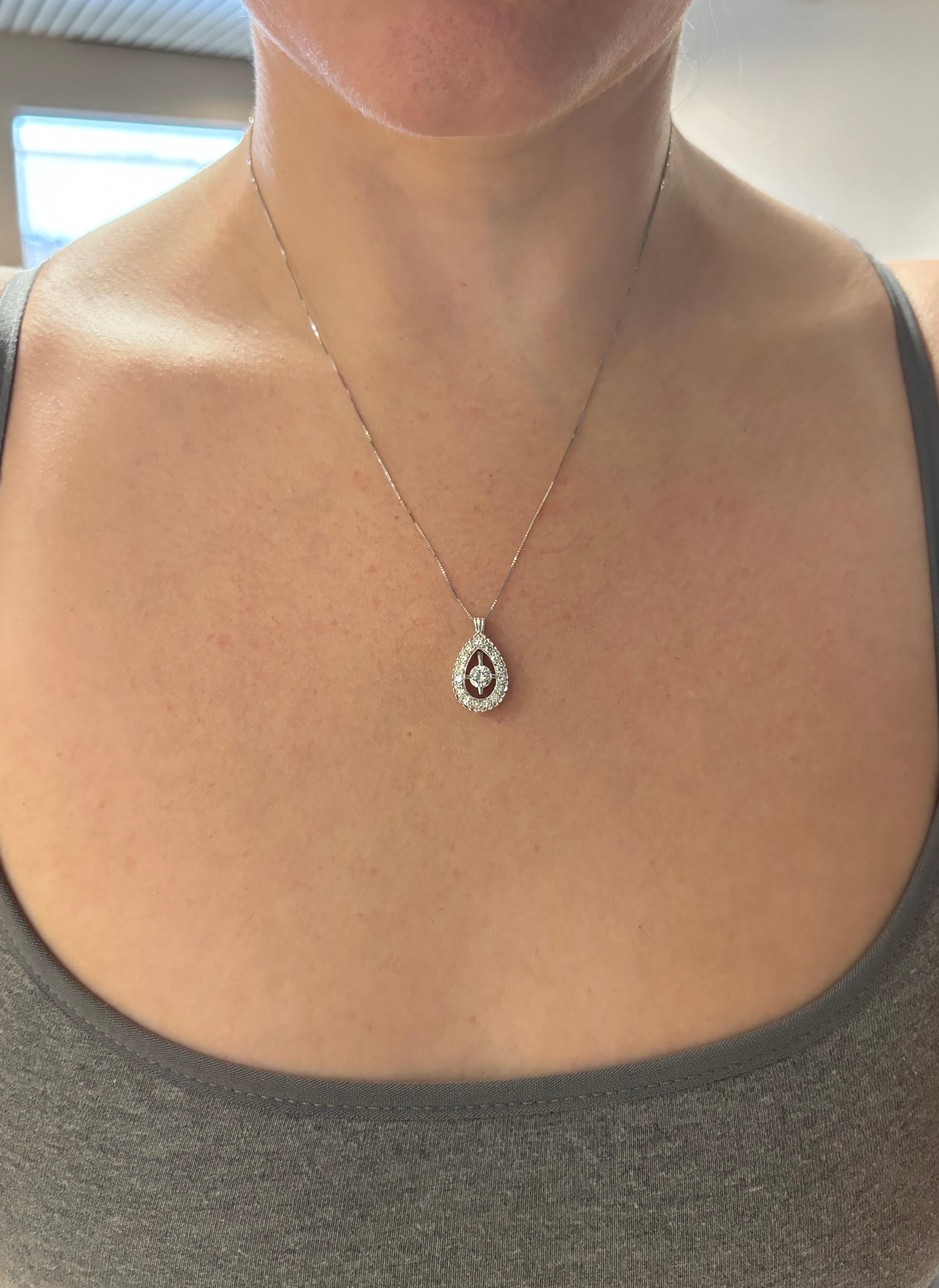 Vintage Diamond halo pendant necklace made with .91ctw of Diamonds. 
 
Gemstone: Earth Mined Diamond
Center Diamond Carat Weight: .46ct Round Brilliant Cut 
Center Diamond Color: E-F
Center Diamond Clarity: VS2
Total Diamond Carat Weight: