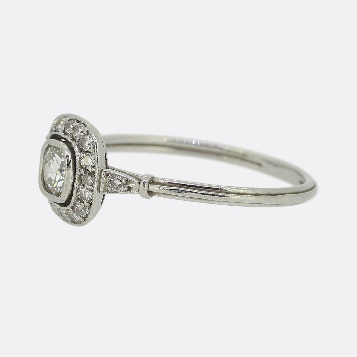 Here we have a fabulous diamond halo ring. Crafted in platinum this vintage ring features a central 0.30 carat round brilliant cut diamond which is surrounded by a border of 16 smaller diamonds. In ring has been designed in a typical Art Deco style
