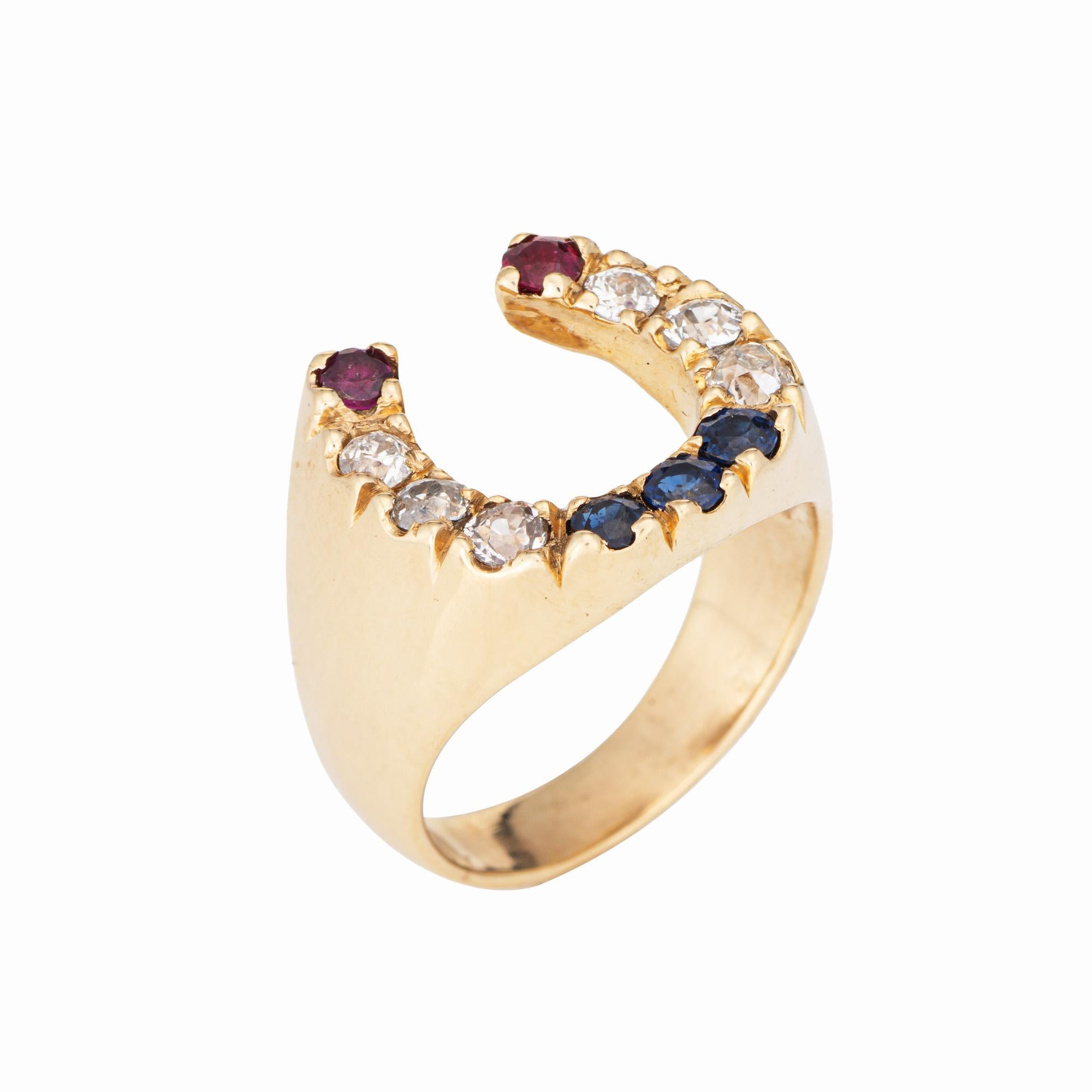 Elegante anillo vintage en forma de herradura de diamantes, zafiros y rubíes (circa años 70), elaborado en oro amarillo de 14 quilates. 

Los diamantes tienen un total estimado de 0,60 quilates (color estimado I-J y claridad SI1-I1). Los zafiros y
