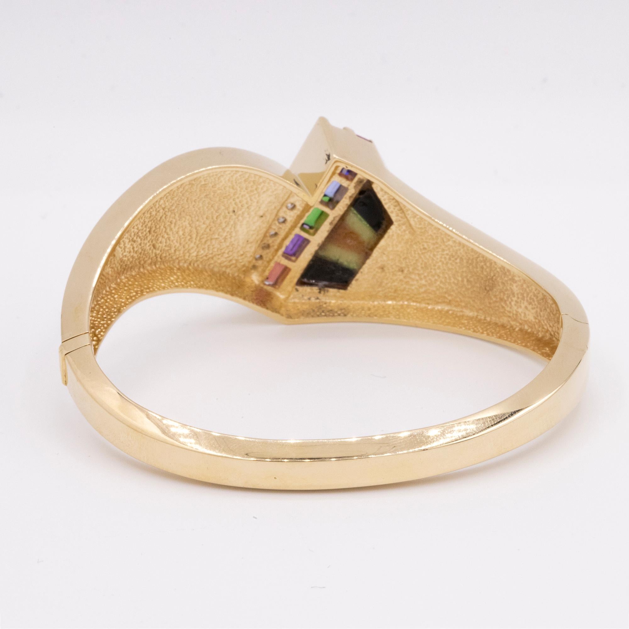 Vintage 14 karat Yellow Gold Cuff with 10 Graduated Diamonds, Multi-Colored Sapphires, inlaid handstone and a fiery Opal. The cuff measures 6mm by 7mm and has a hinge push to open clasp. It has been expertly restored by our Master Jewelers.
