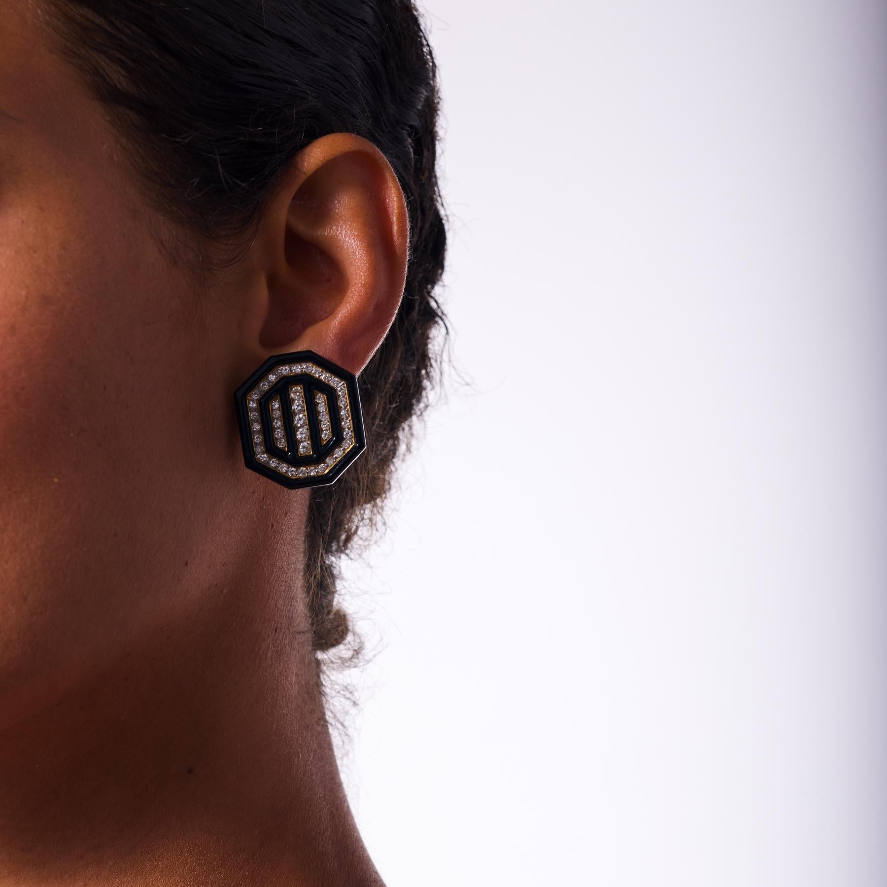 Radiosi e audaci, questi orecchini a clip vintage degli anni '80 mostrano il sorprendente contrasto tra i diamanti scintillanti e l'elegante onice nera. Novanta diamanti rotondi taglio brillante scintillano con un fuoco nitido, incastonati con