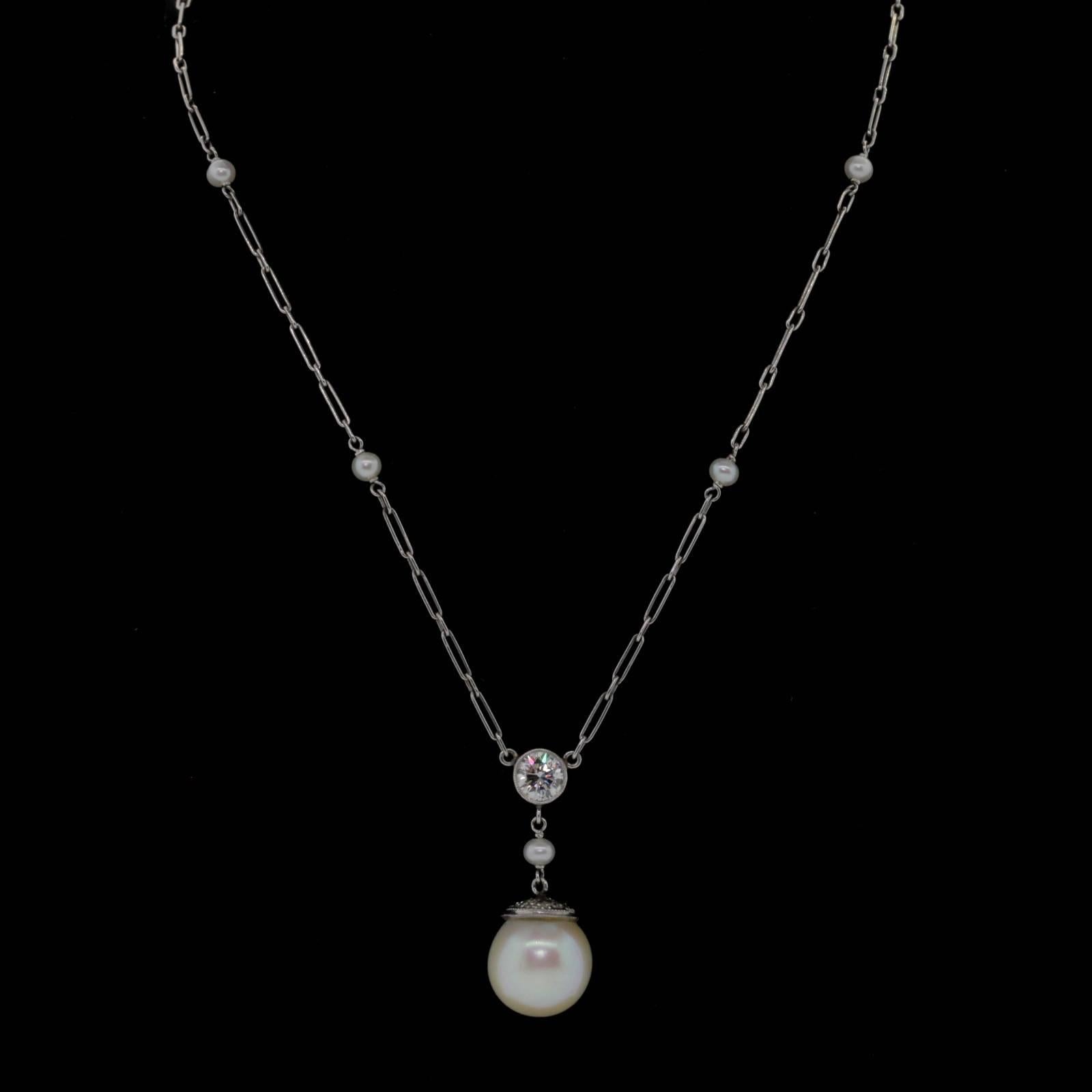 This very wearable platinum pendant necklace features a bezel set 0.45 carat Round Brilliant cut Diamond, hanging from a handmade wire link chain.  A cultured 10.15 mm Pearl with a diamond cap dangles from the diamond.  Completing this lovely