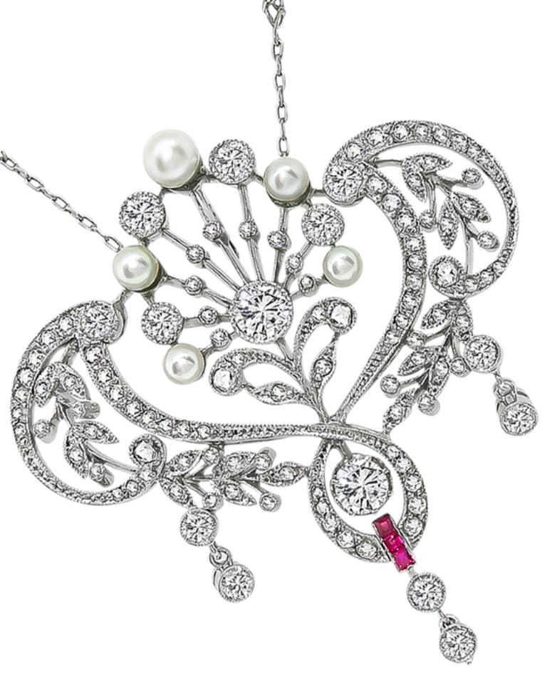 This stunning platinum pendant necklace is set with sparkling old European and rose cut diamonds that weigh approximately 3.90ct. graded G-I color with VS2 clarity. The diamonds are accentuated by lovely ruby and pearl accents.
The chain on the