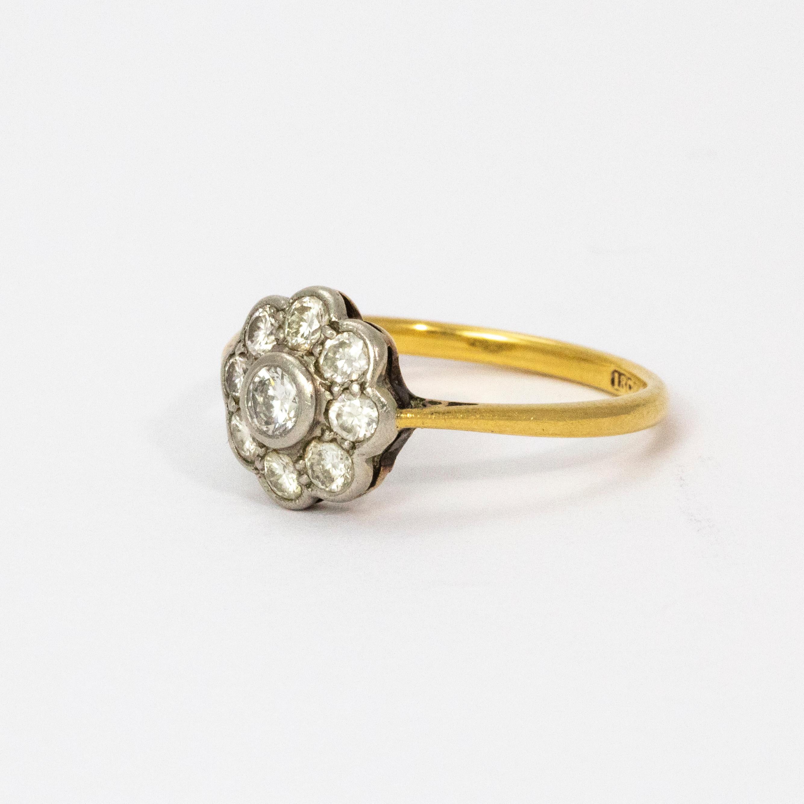 A Stunning vintage cluster ring. A larger white old European cut diamond surrounded by an elegant halo of eight diamonds, total diamond weight 65 points. The stones are set in platinum while the rest of the ring is modelled in 18 karat yellow