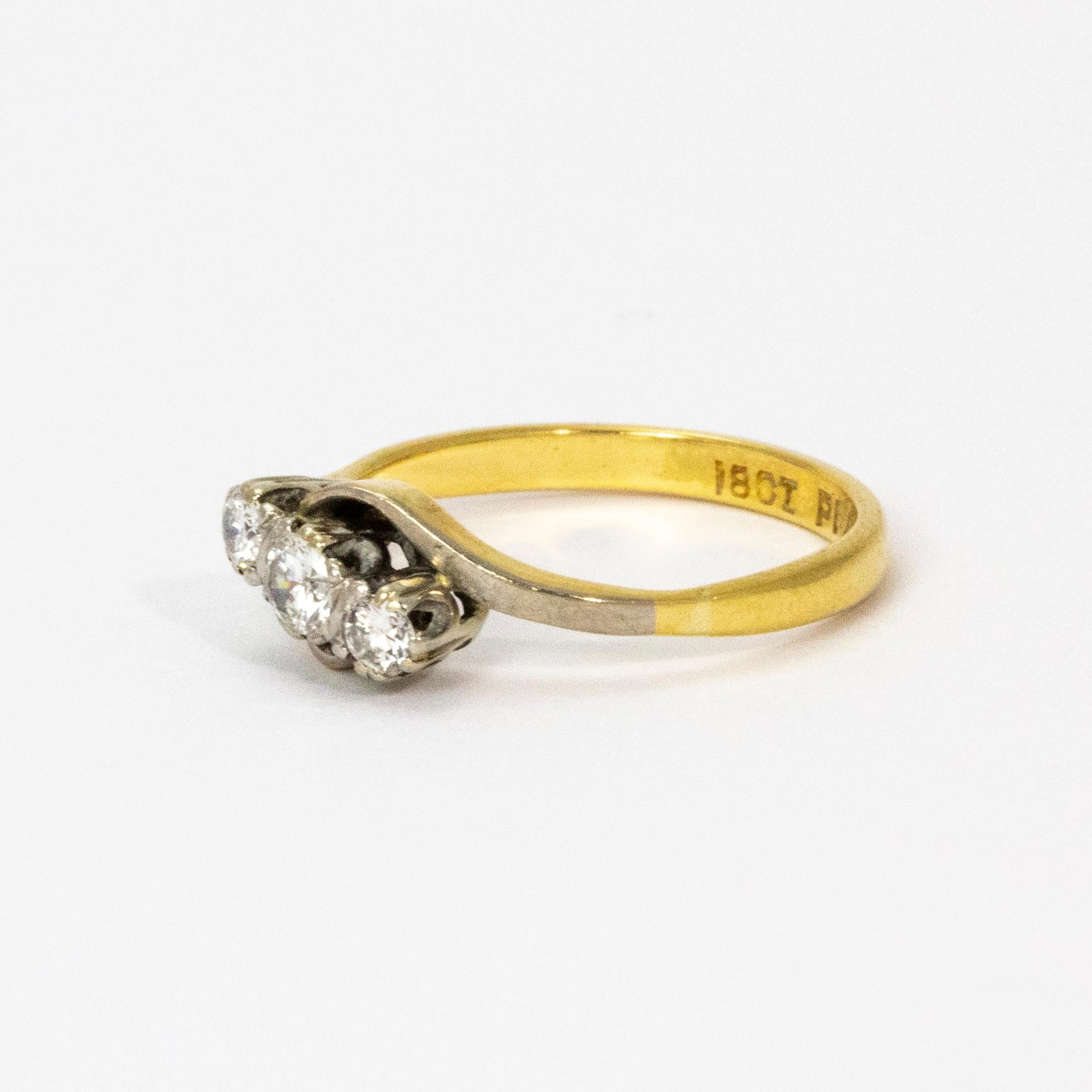 An elegant vintage three-stone ring, set with a diagonal row of beautiful old European cut diamonds. The stones are set in platinum which extends to the shoulders which have great curved design. Band Modelled in 18 karat yellow gold.

Ring Size: K