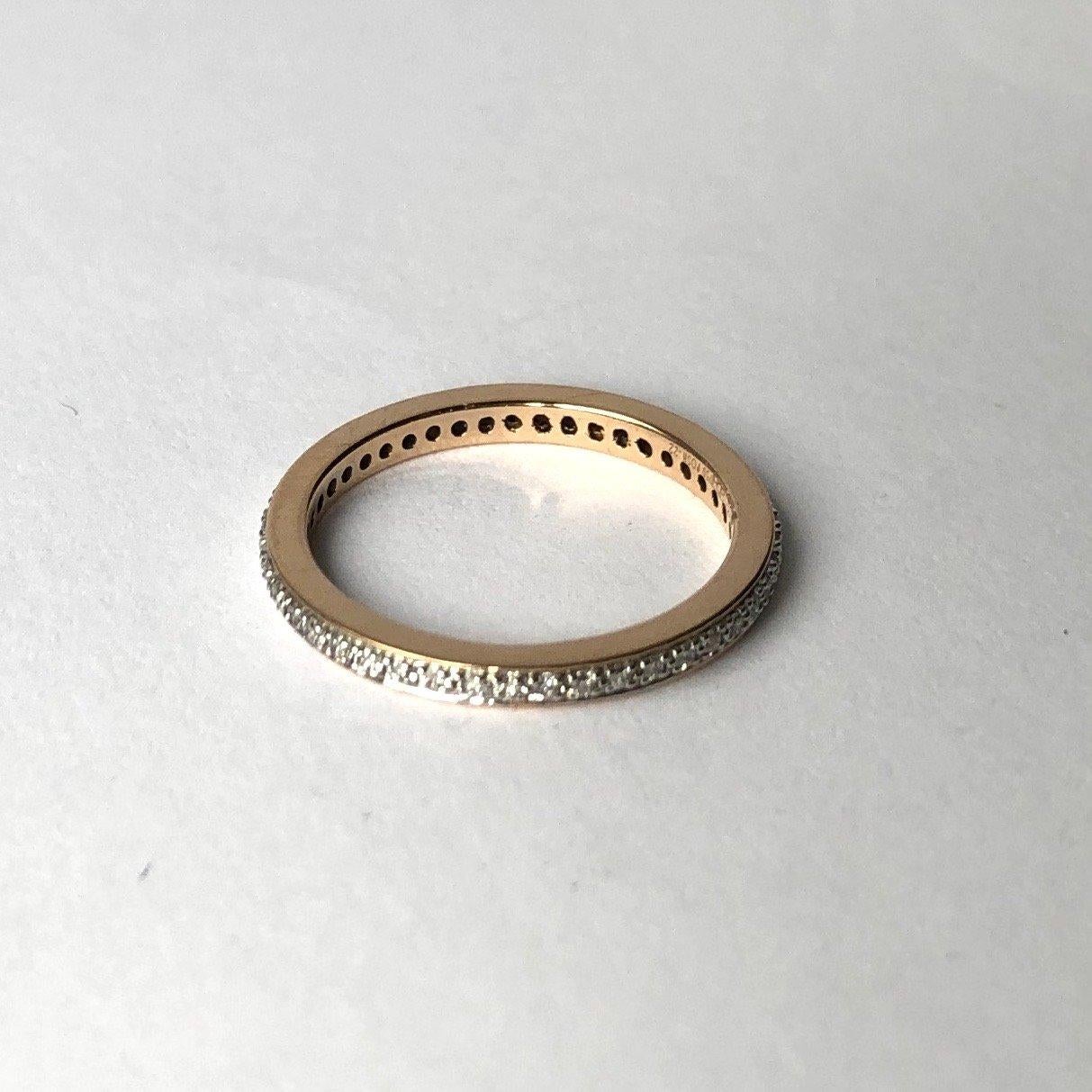 This eternity band holds small yet sparkly diamonds measuring approximately 1pt each. The diamonds are set in textured settings which makes them appear larger and add to the sparkle. The rest of the ring is modelled in yellow gold which is visible