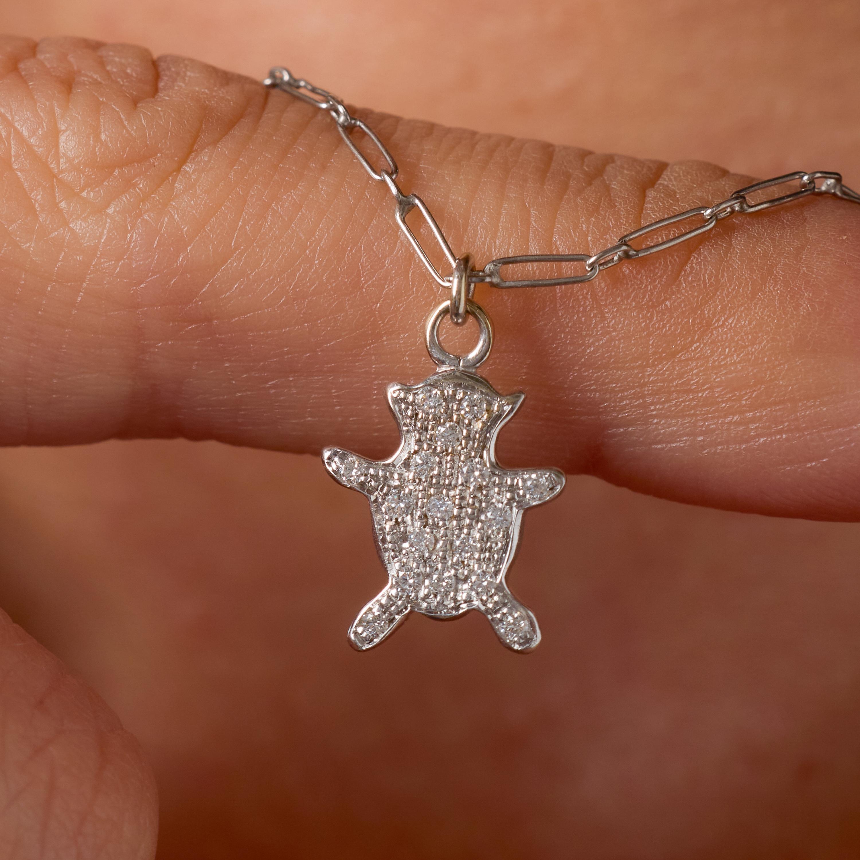 Ce ravissant collier vintage en platine est orné d'un ours fantaisiste méticuleusement décoré de quinze diamants ronds de taille brillant. D'un poids combiné d'environ 0,15 carat et d'une couleur F et d'une pureté VS exceptionnelles, les diamants