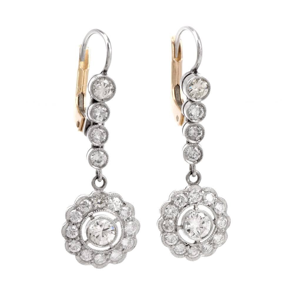 These alluringly feminine vintage earrings of classic elegance are crafted in Solid Platinum with 18K yellow gold back, weigh 4.9 grams and measure 32 x 10 mm. The earrings incorporate orbicular plaques, centered with round-cut diamonds mounted